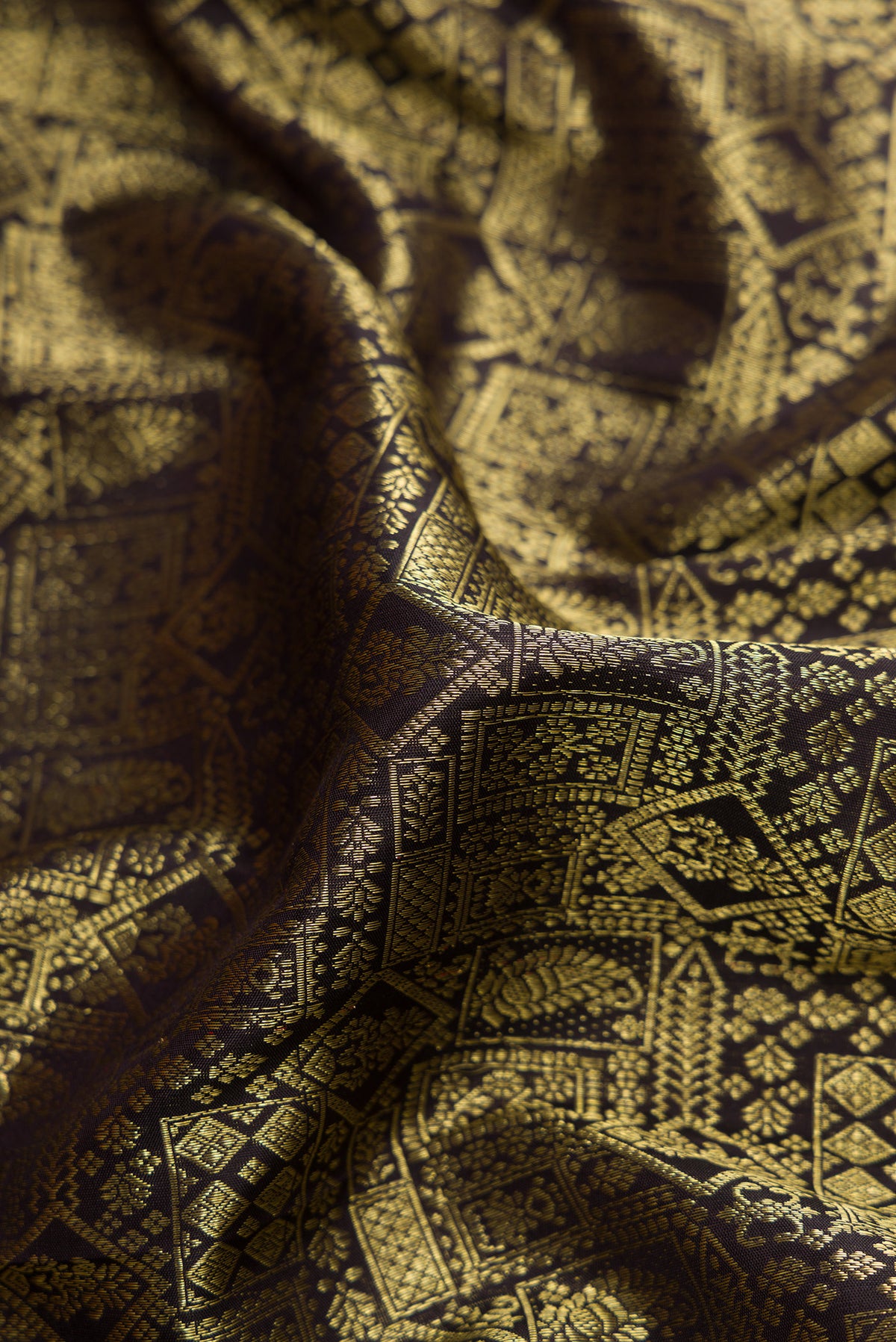 Close up of Black Kanjivaram Silk Saree with Zari Brocade on the body and Zari Border.  displaying folds