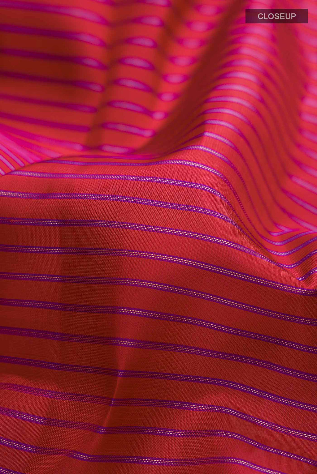 Close up of Maroon Kanchipuram Silk Saree with Stripes on the body and Zari Border displaying folds