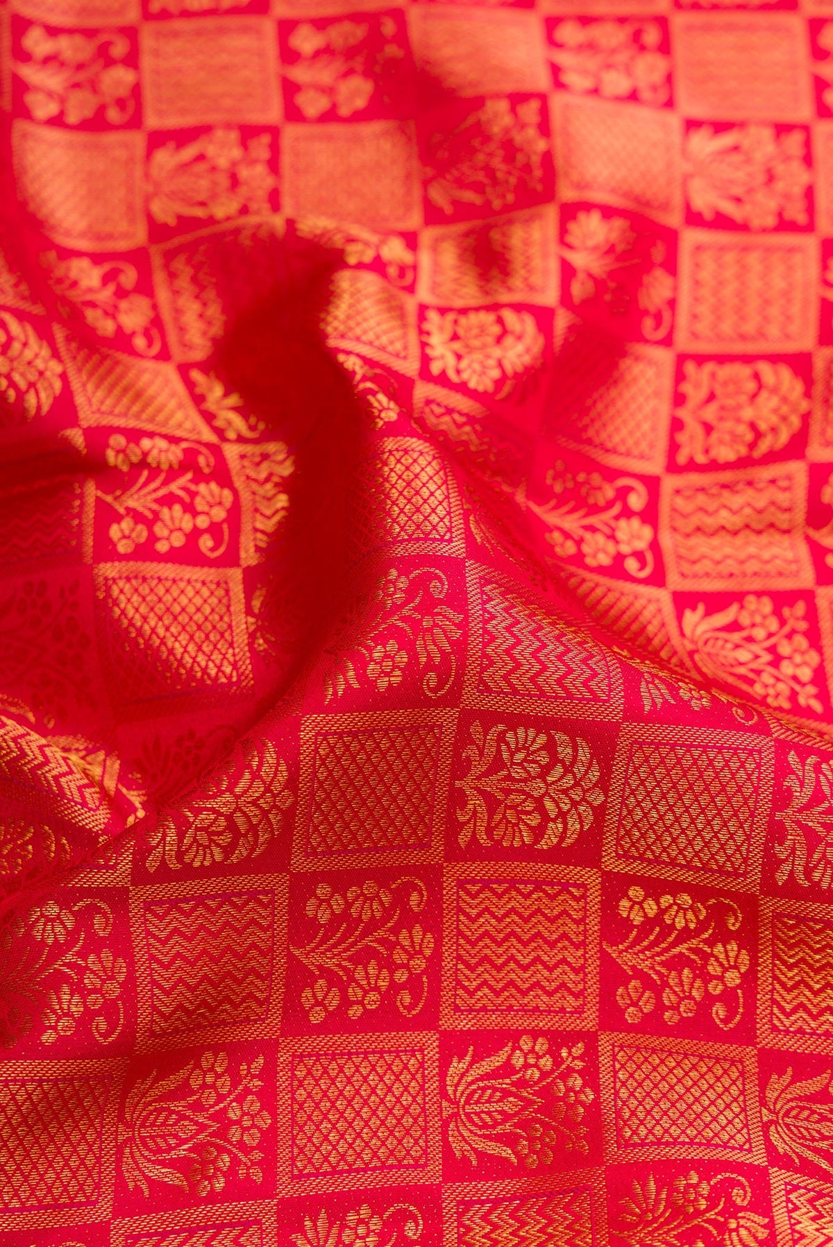 Close up of Red Kanchipuram Silk Saree with Zari Brocade on the body and Zari Border.  displaying folds