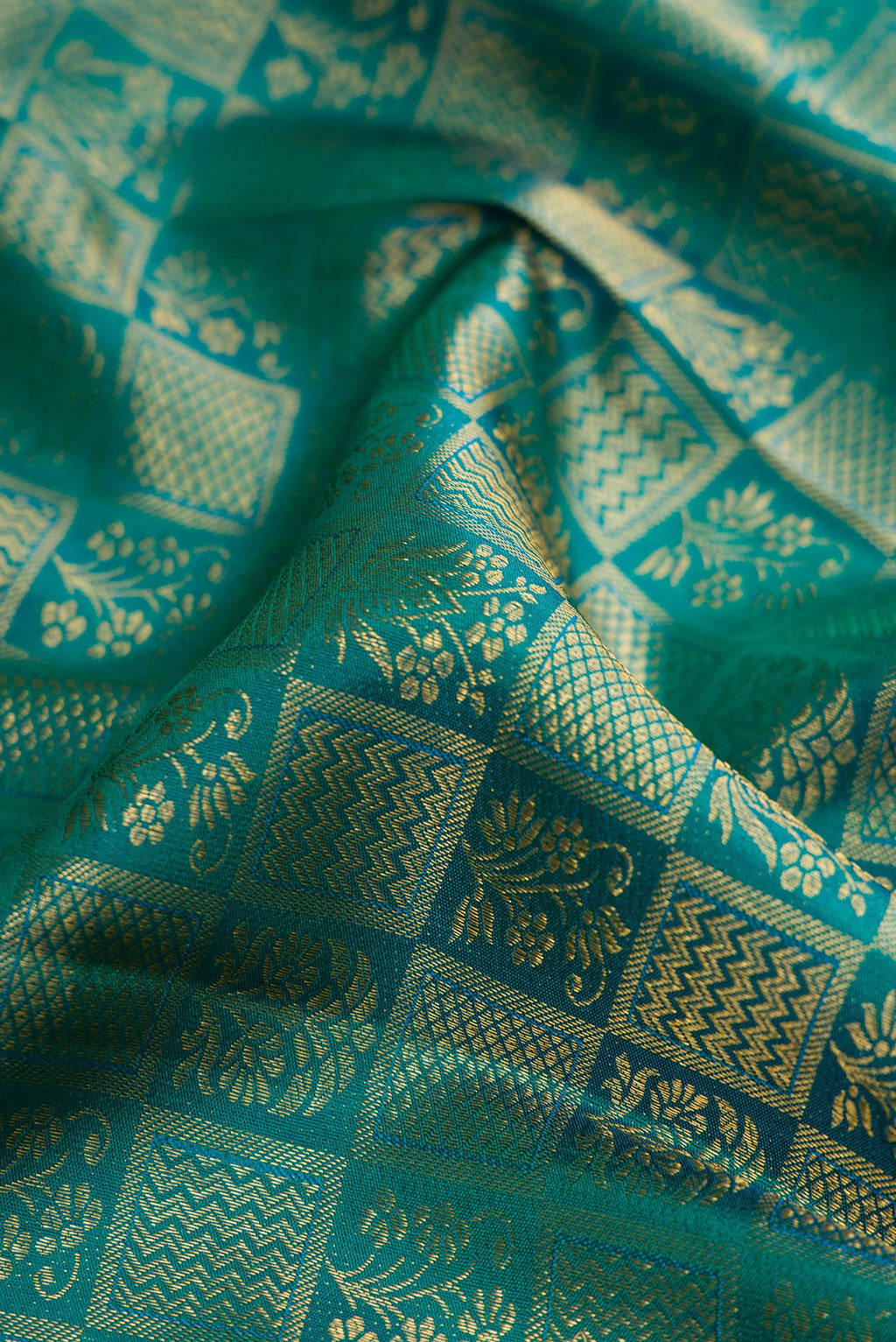 Close up of Green Kanchipuram Silk Saree with Zari Brocade on the body and Zari Border.  displaying folds