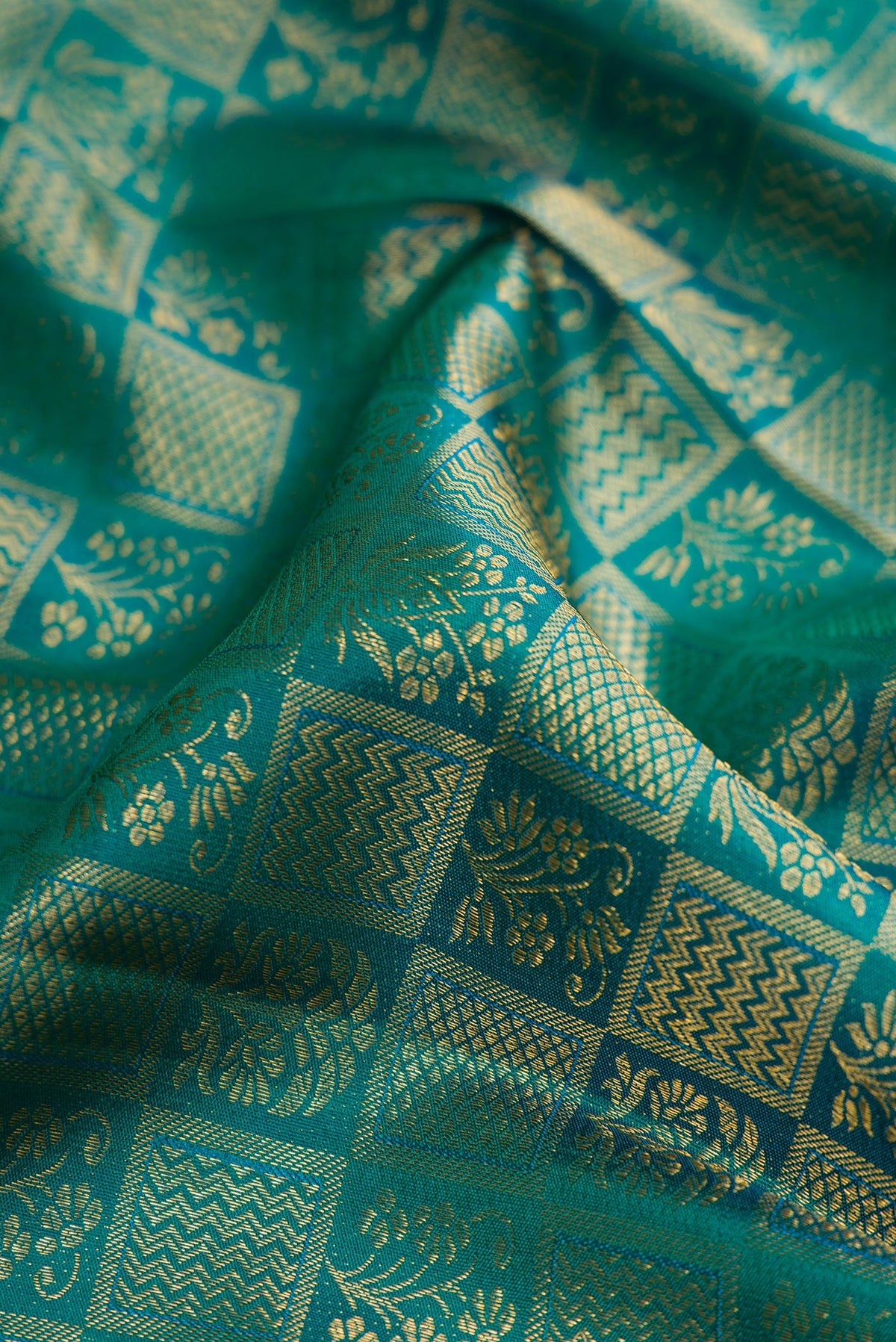 Close up of Green Kanchipuram Silk Saree with Zari Brocade on the body and Zari Border.  displaying folds