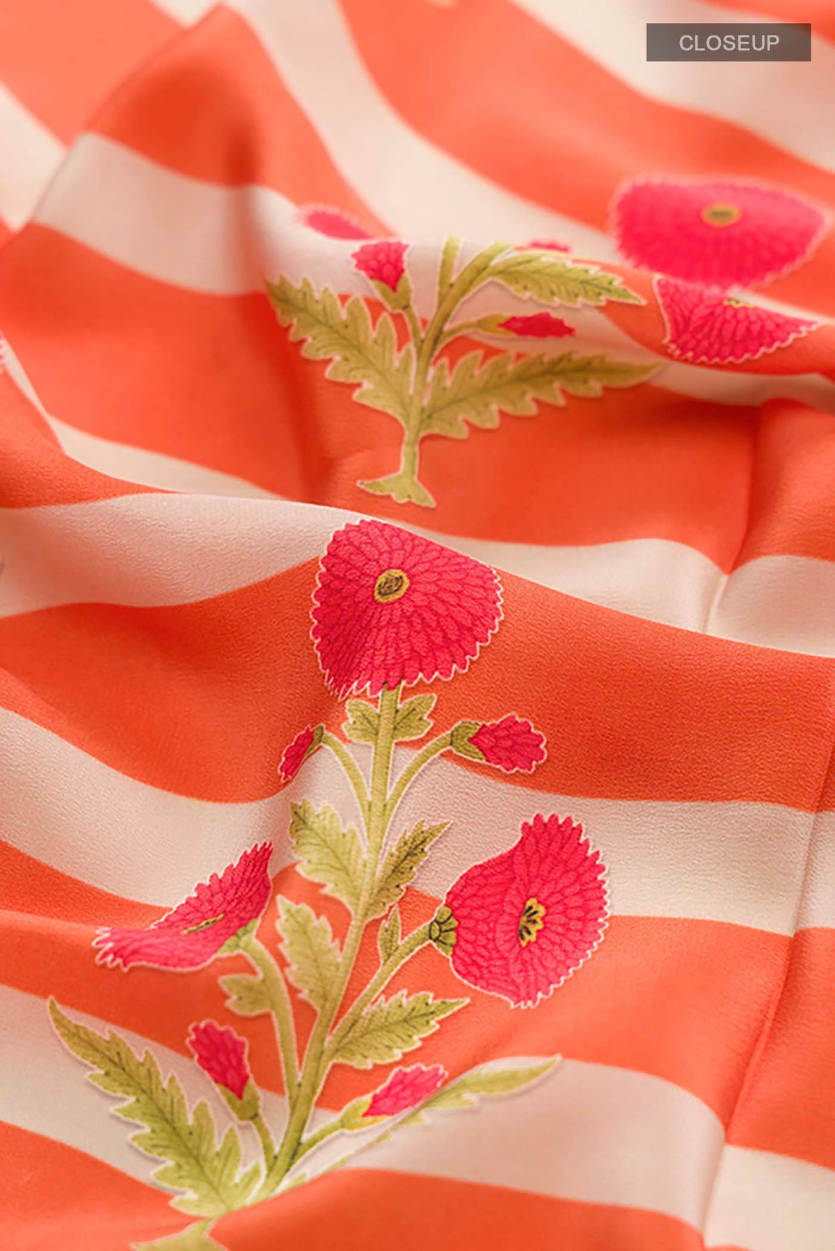 Close up of Orange Mysore Crepe Saree with Printed design on the body and Plain Border displaying folds