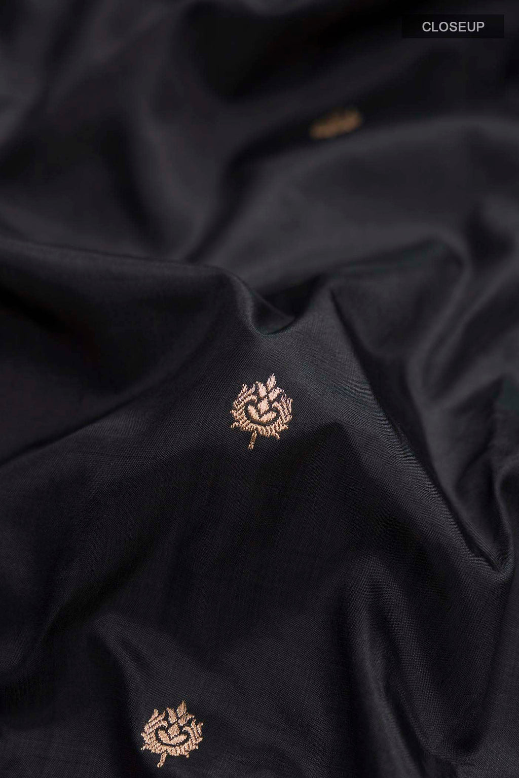 Close up of Black Banarasi Katan Silk Saree with Zari Butta on the body and Zari Border displaying folds
