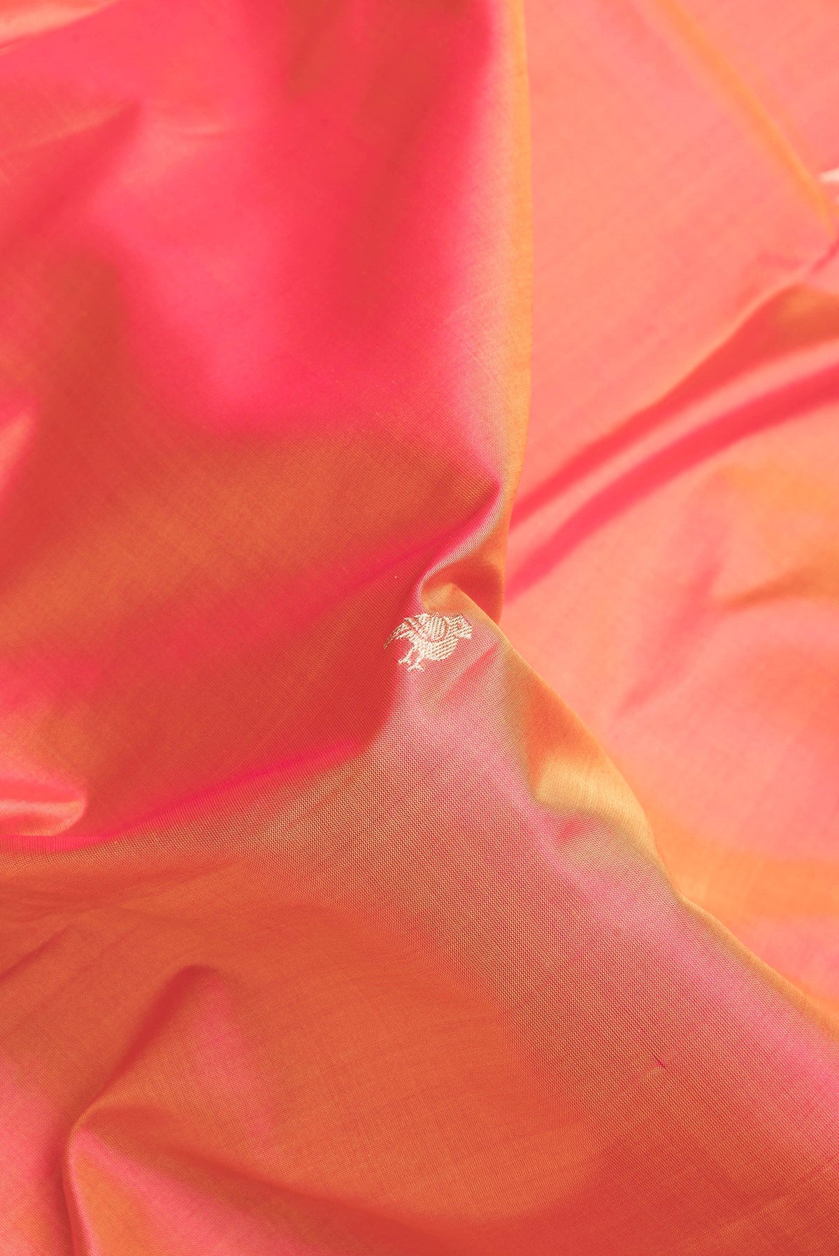 Close up of Coral Dual Tone Banarasi Silk Saree with Zari Butta on the body and Zari Border.  displaying folds