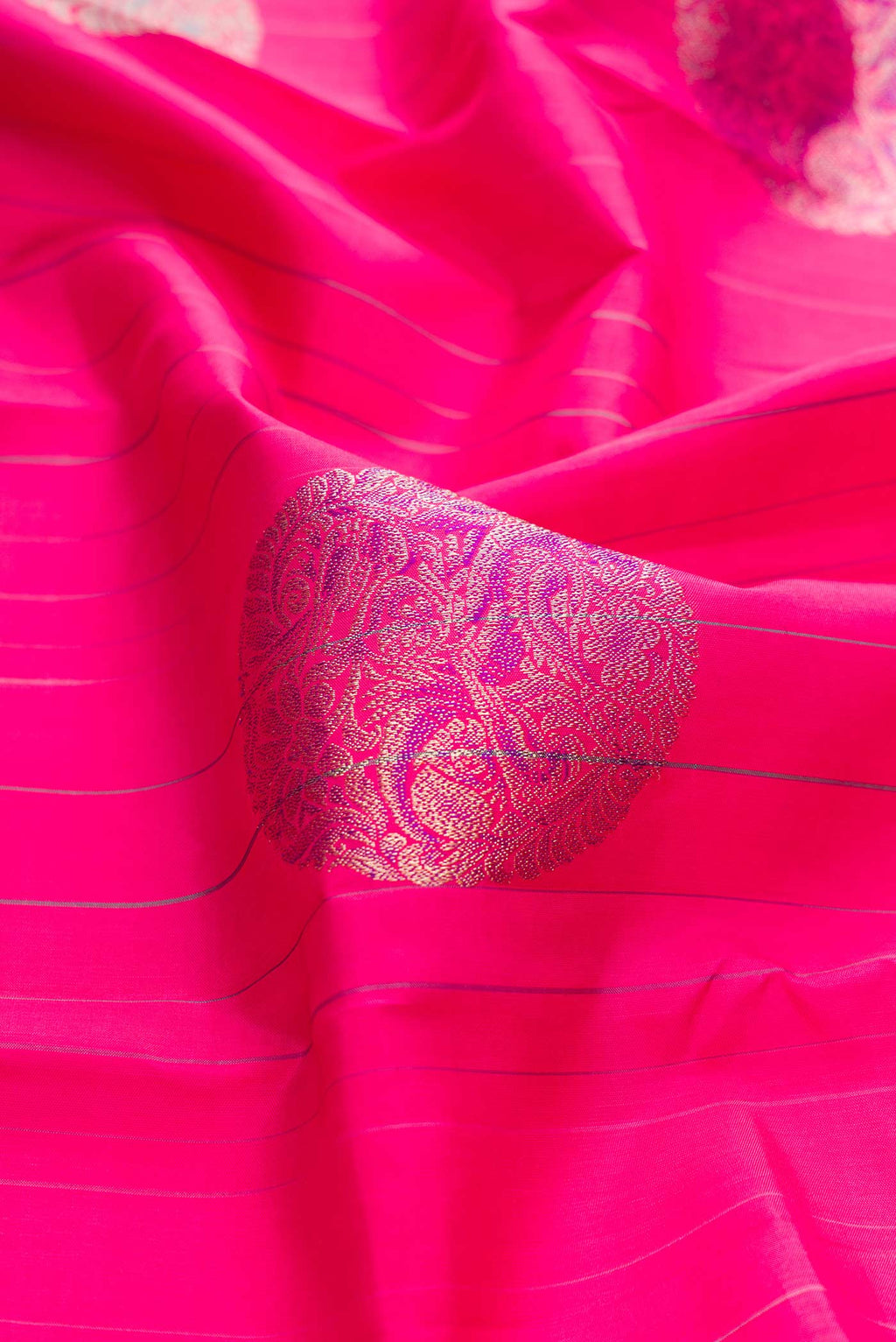 Close up of Dark Pink Dual Tone Kanchipuram Silk Saree with Zari And Thread Butta on the body and Without Border displaying folds