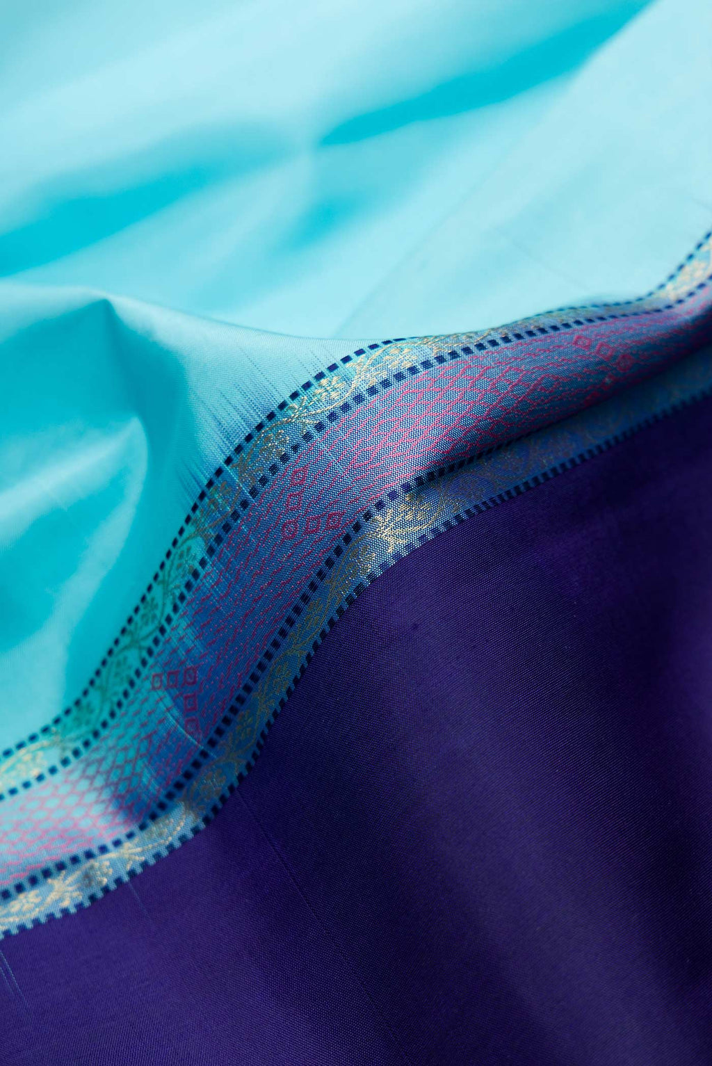 Close up of Sky Blue and Navy Blue Color Kanchipuram Silk Saree with Half And Half on the body and Without Border displaying folds