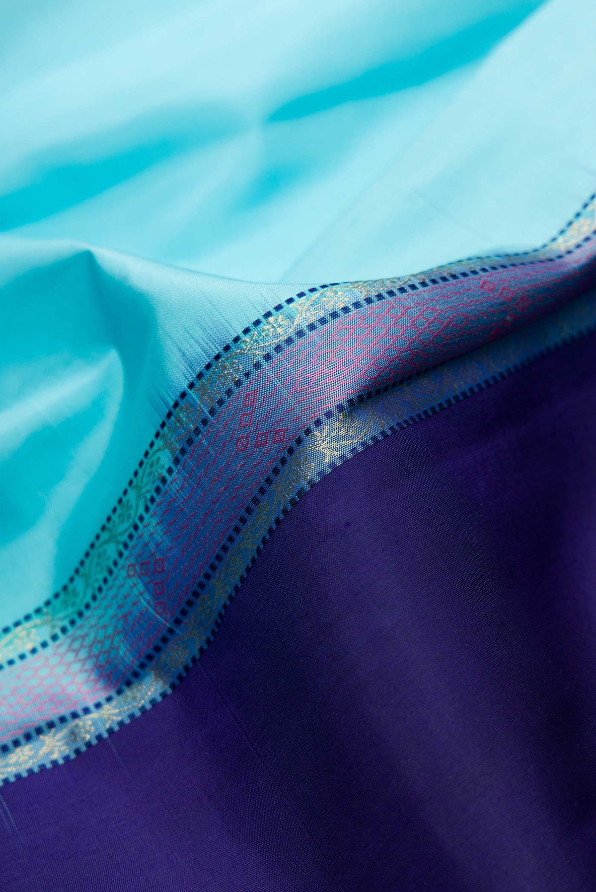 Close up of Sky Blue and Navy Blue Color Kanchipuram Silk Saree with Half And Half on the body and Without Border displaying folds