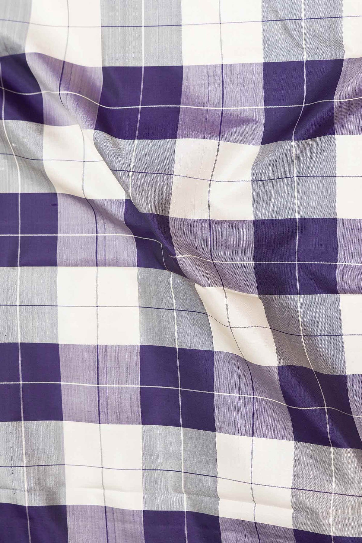 Close up of Grey,Off White and Navy Blue Color Kanchipuram Saree with Checked design on the body and Zari Border displaying folds