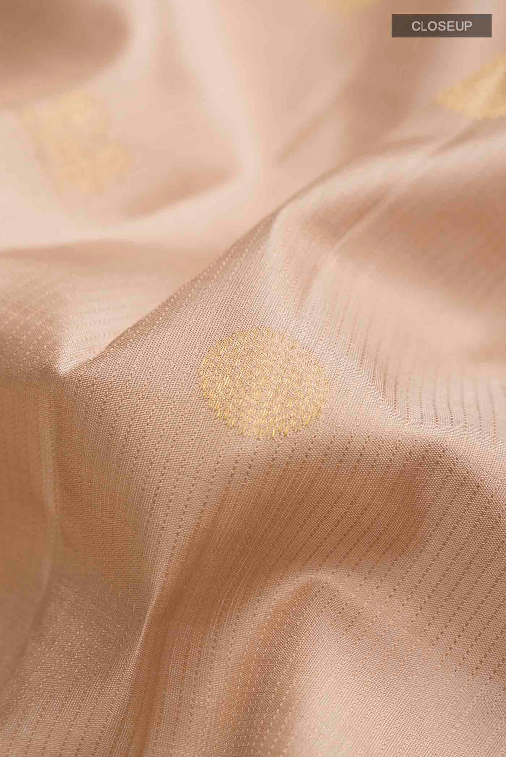 Close up of Beige Kanchipuram Silk Saree with Zari Butta on the body and Zari Border displaying folds