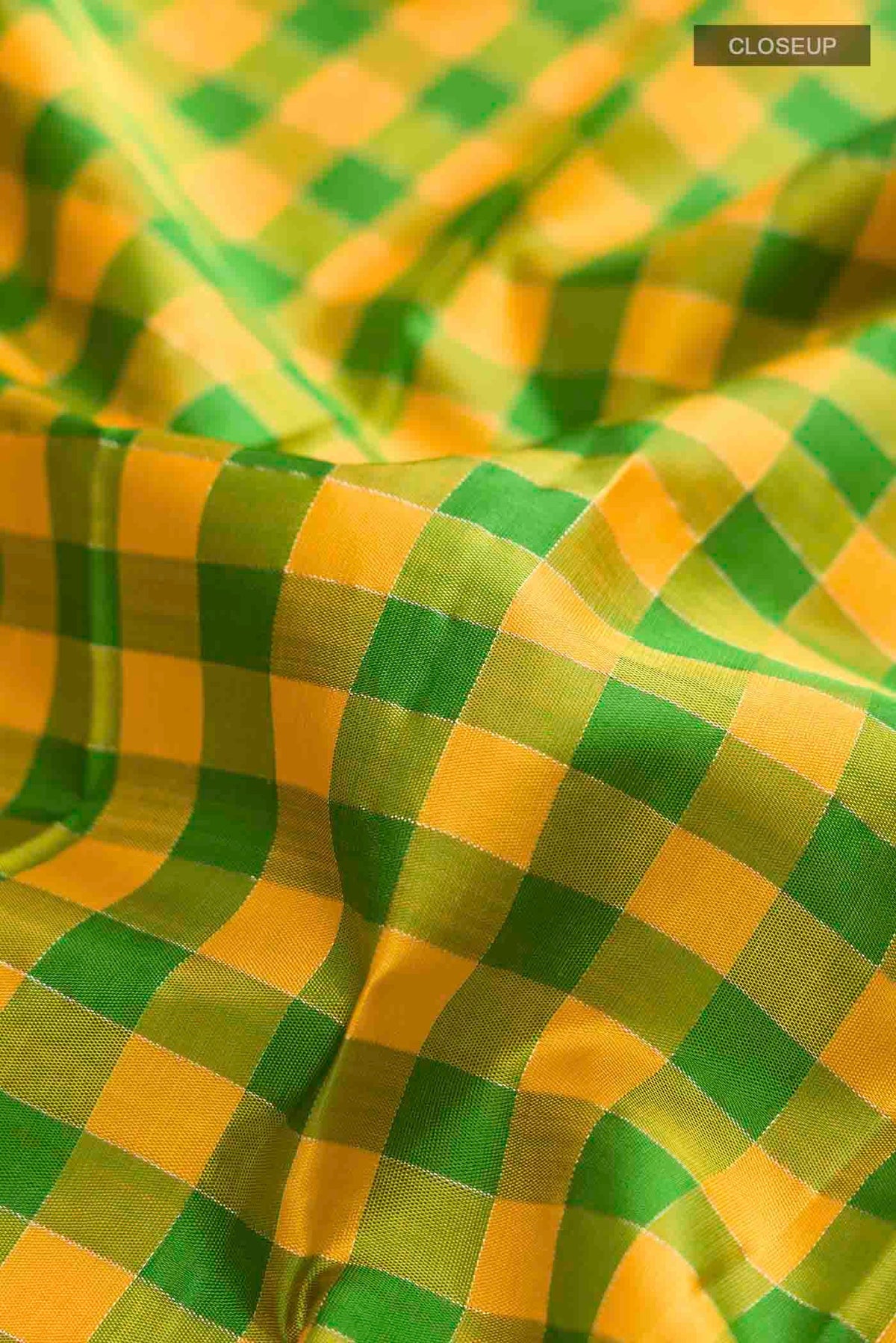 Close up of Multi Color Kanchipuram Silk Saree with Checked design on the body and Zari Border displaying folds