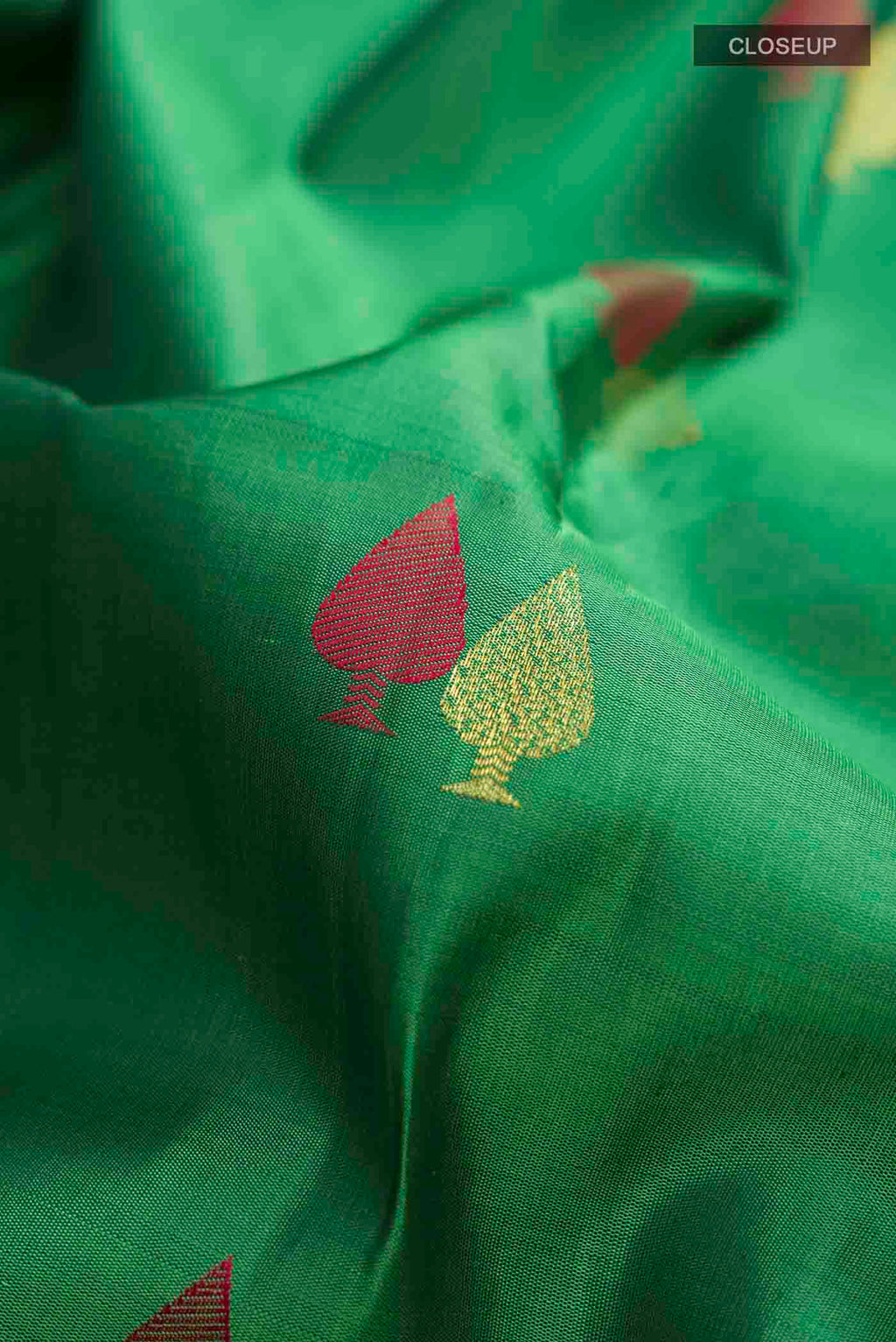 Close up of Green Kanchipuram Silk Saree with Zari Butta on the body and Zari Border displaying folds