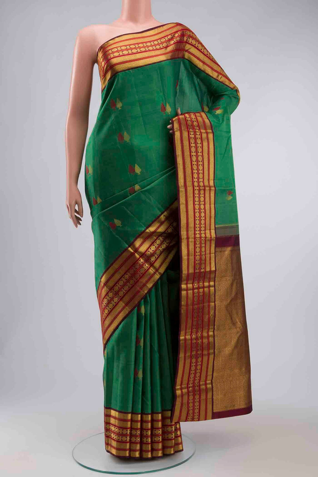 Green Kanchipuram Silk Saree with Zari Butta on the body and Zari Border displayed on a mannequin