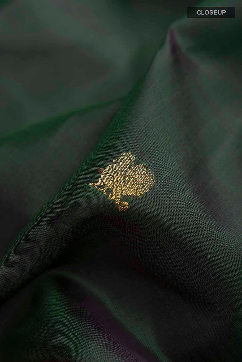 Close up of Green Kanchipuram Silk Saree with Zari Butta on the body and Zari Border displaying folds