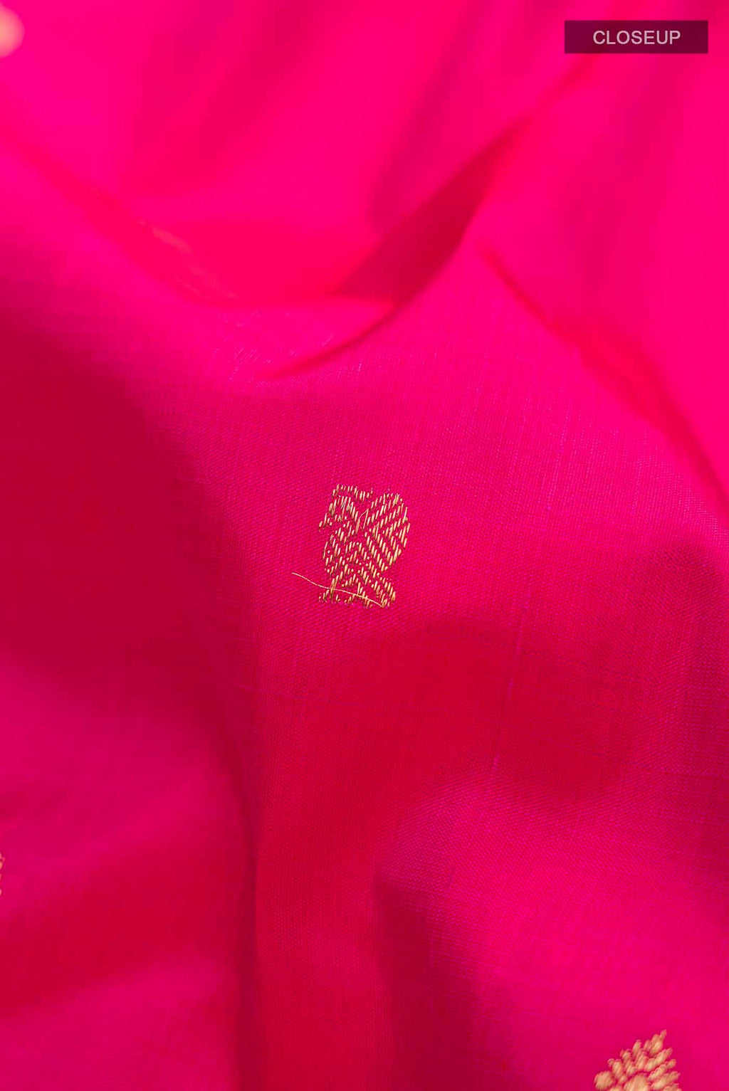 Close up of Pink Kanchipuram Silk Saree with Zari Butta on the body and Zari Border displaying folds