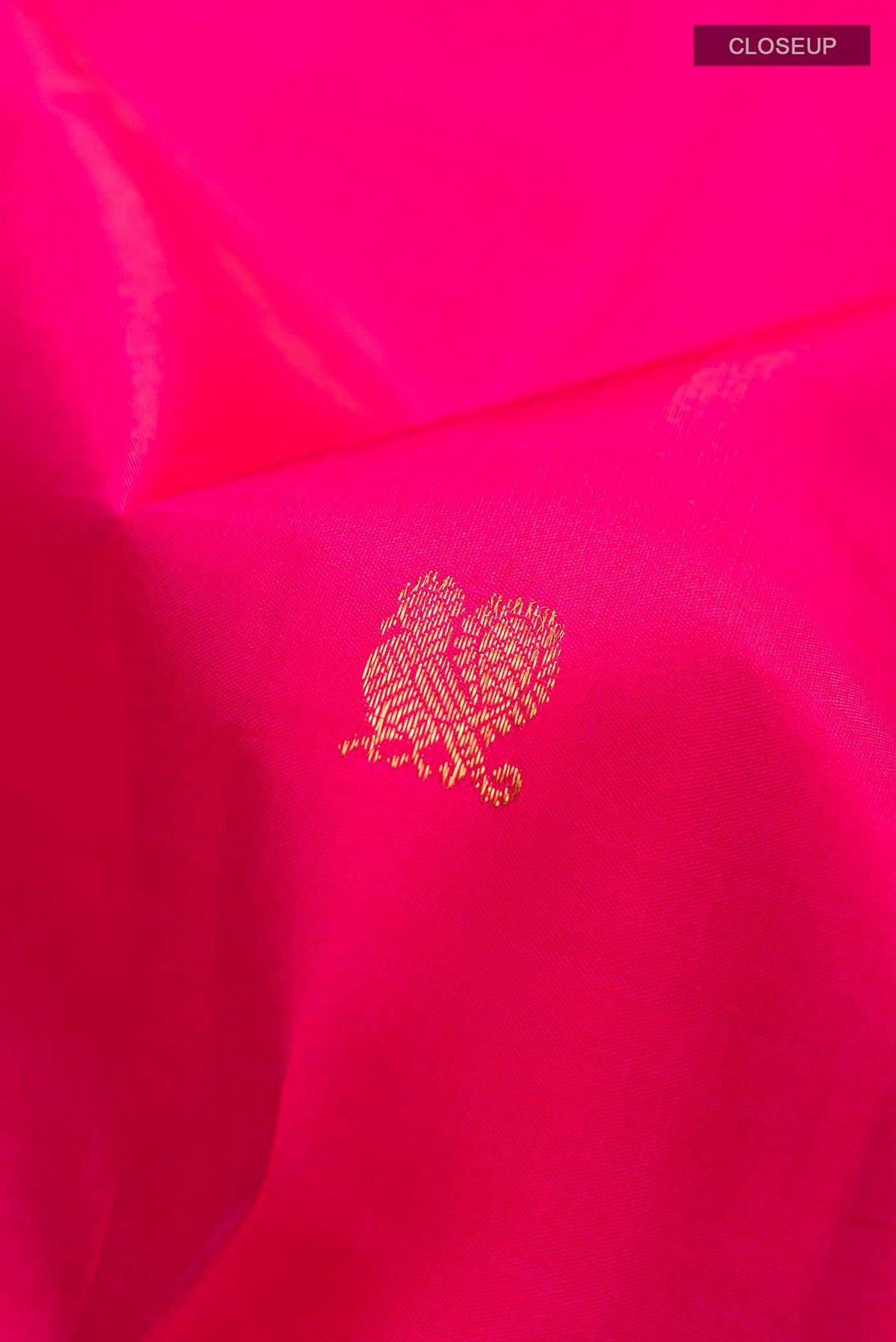 Close up of Pink Kanchipuram Silk Saree with Zari Butta on the body and Zari Border displaying folds