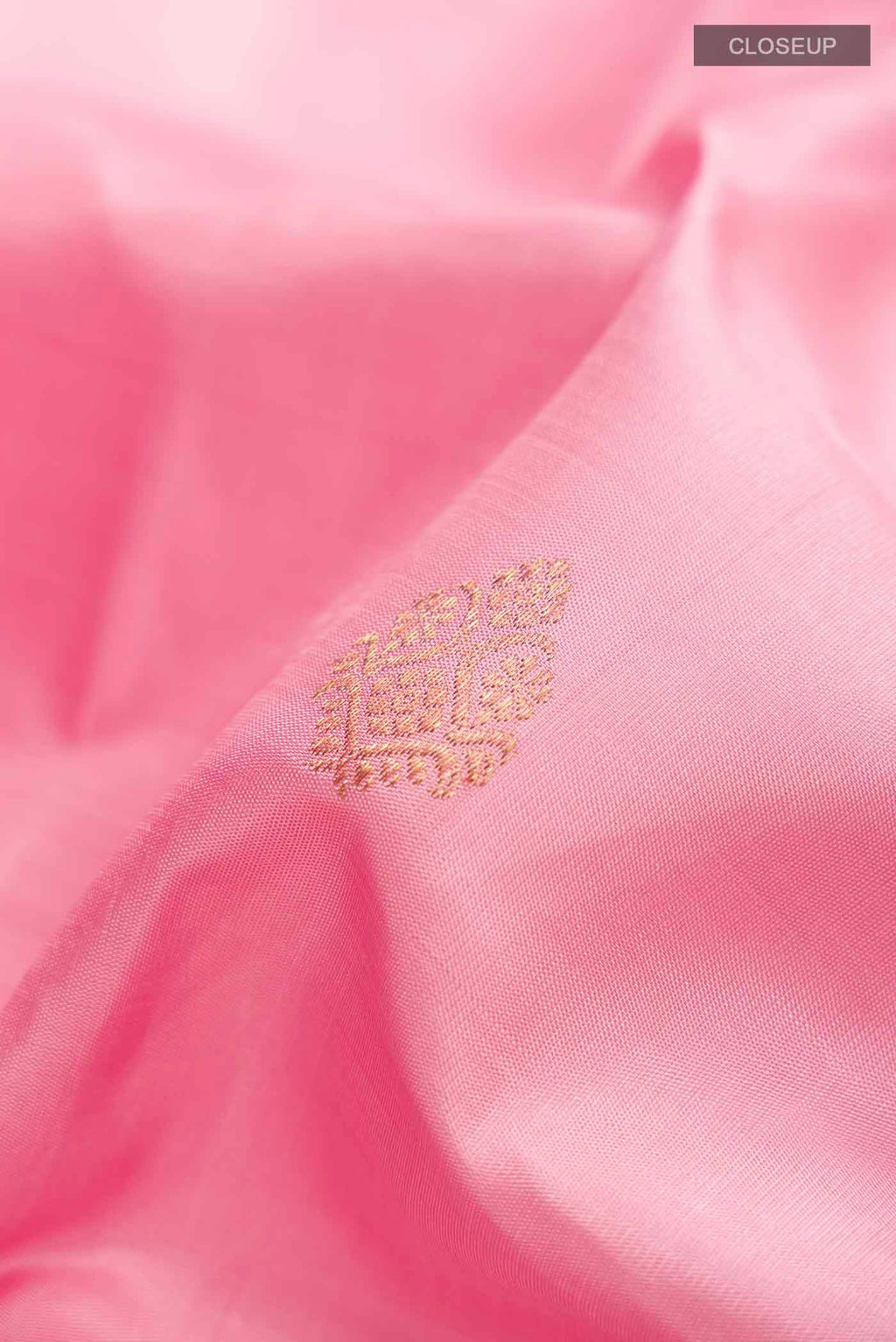 Close up of Pink Kanchipuram Silk Saree with Zari Butta on the body and Zari Border displaying folds