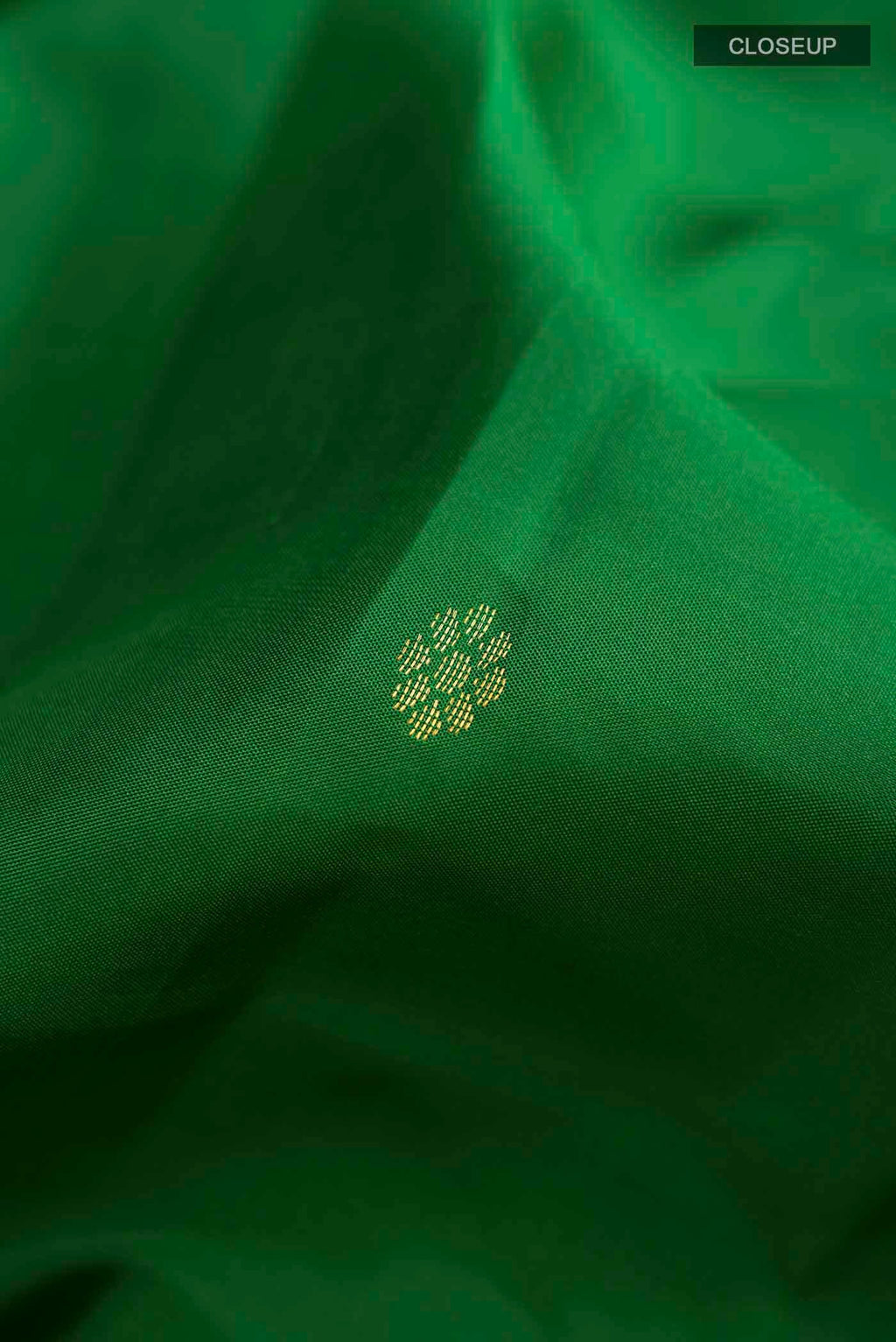Close up of Green Kanchipuram Silk Saree with Zari Butta on the body and Zari Border displaying folds