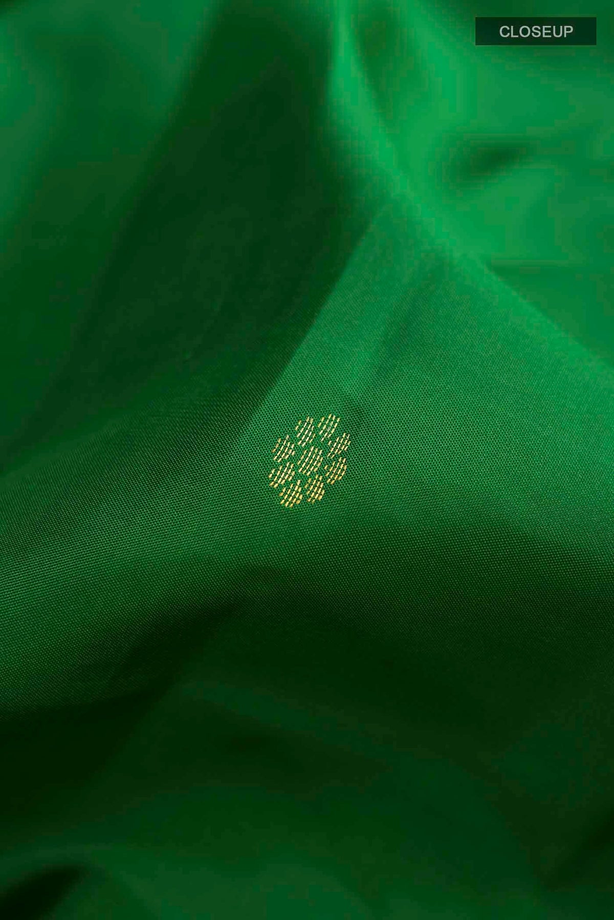 Close up of Green Kanchipuram Silk Saree with Zari Butta on the body and Zari Border displaying folds