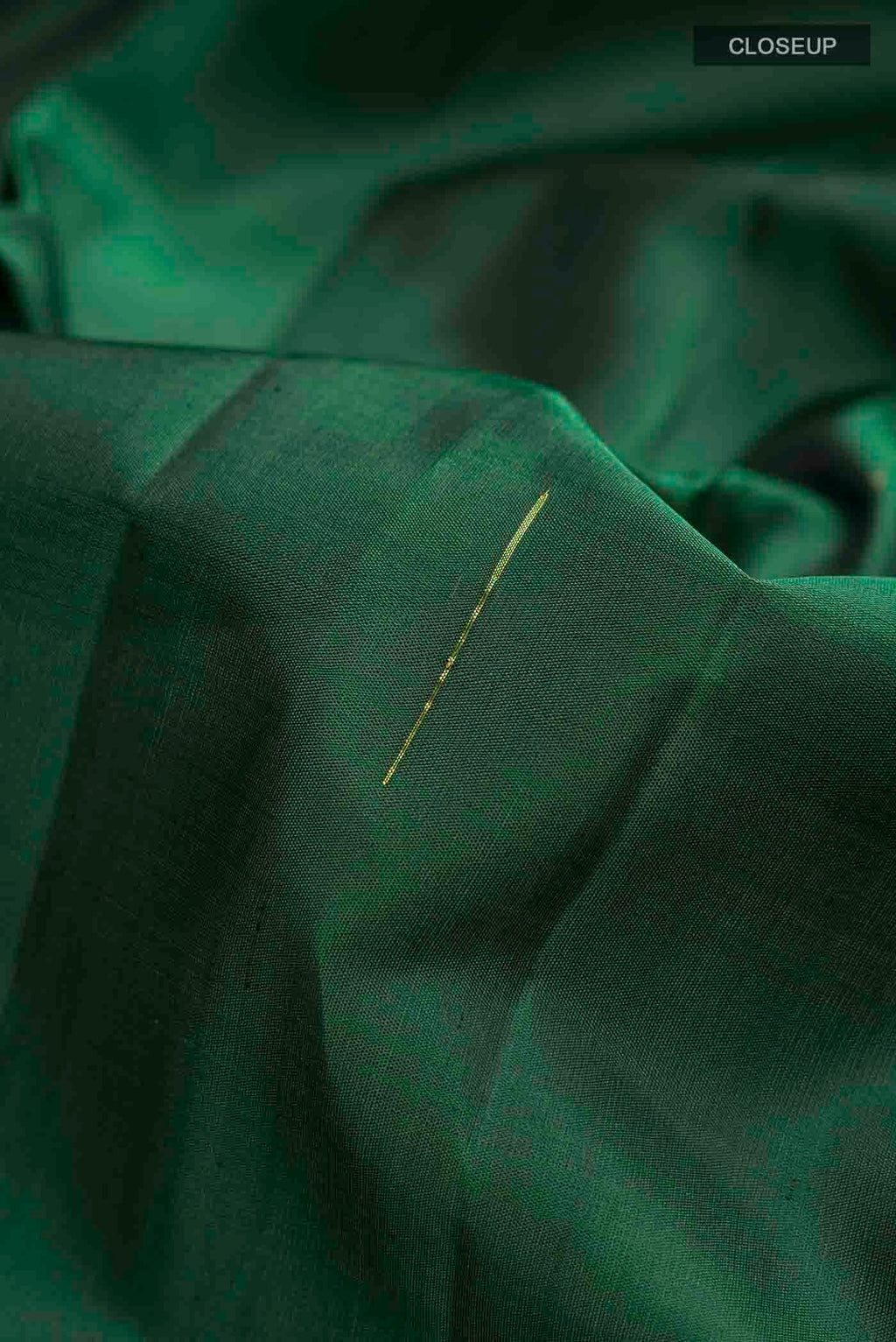 Close up of Green Kanchipuram Silk Saree with Zari Butta on the body and Zari Border displaying folds