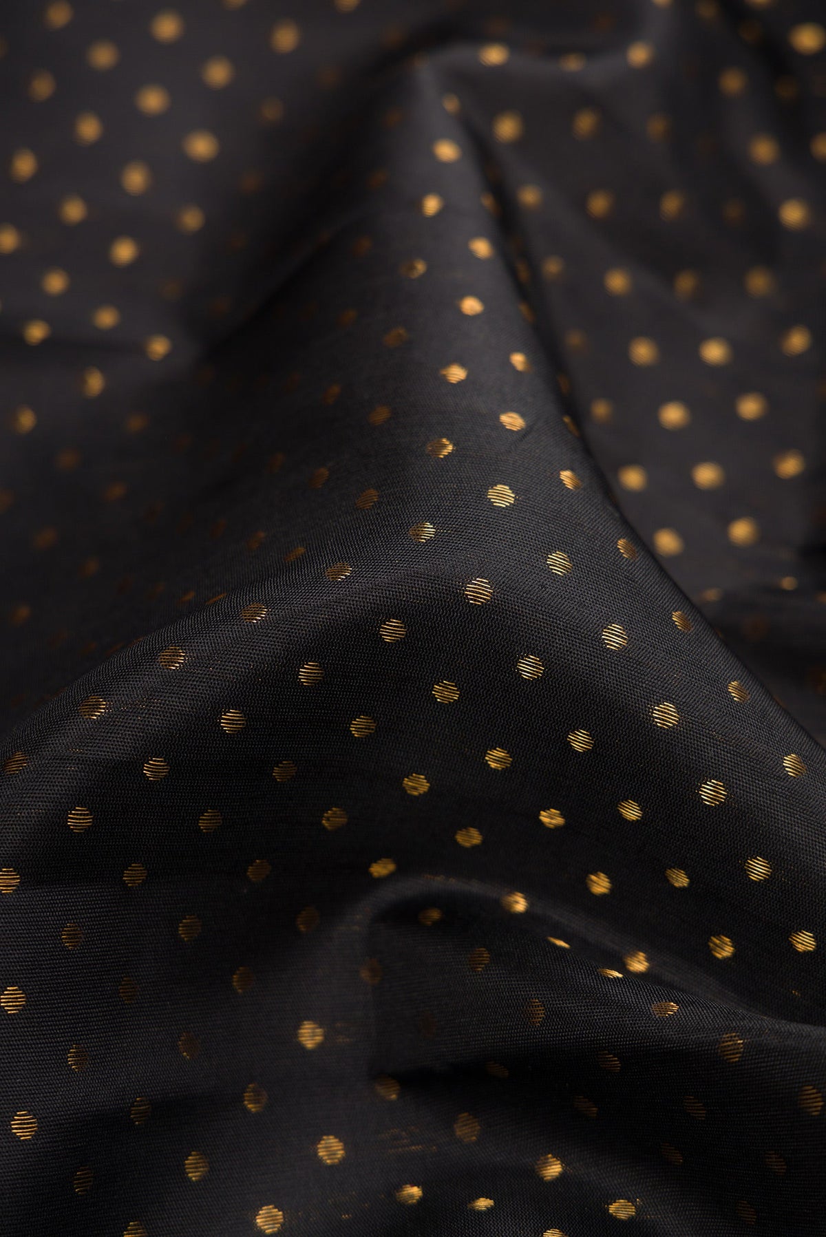 Close up of Pure Silk Pure Zari Black Dual Tone Kanjivaram Saree with Zari Butta on the body and Fancy Border.  displaying folds