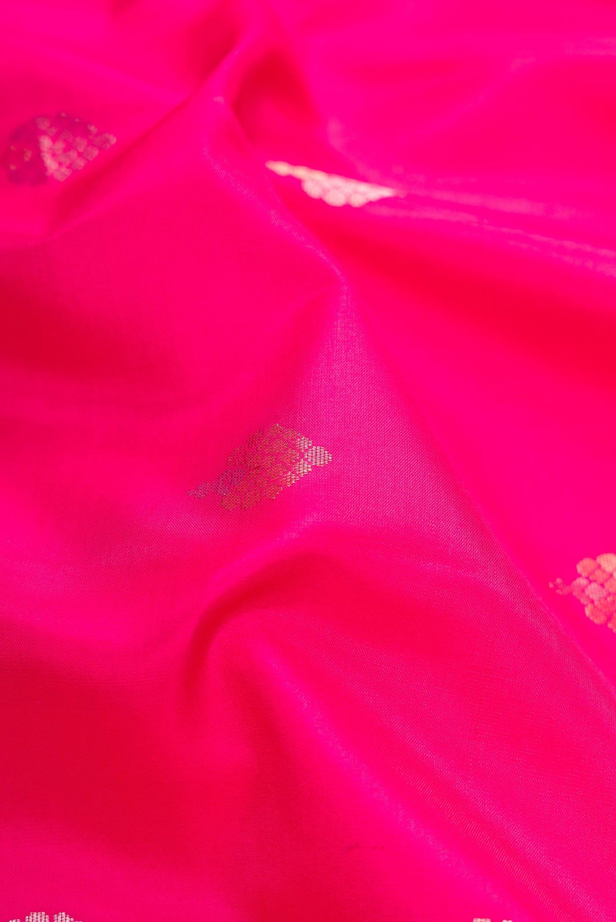 Close up of Pink Dual Tone Soft Silk Saree with Zari Butta on the body and Zari Border.  displaying folds
