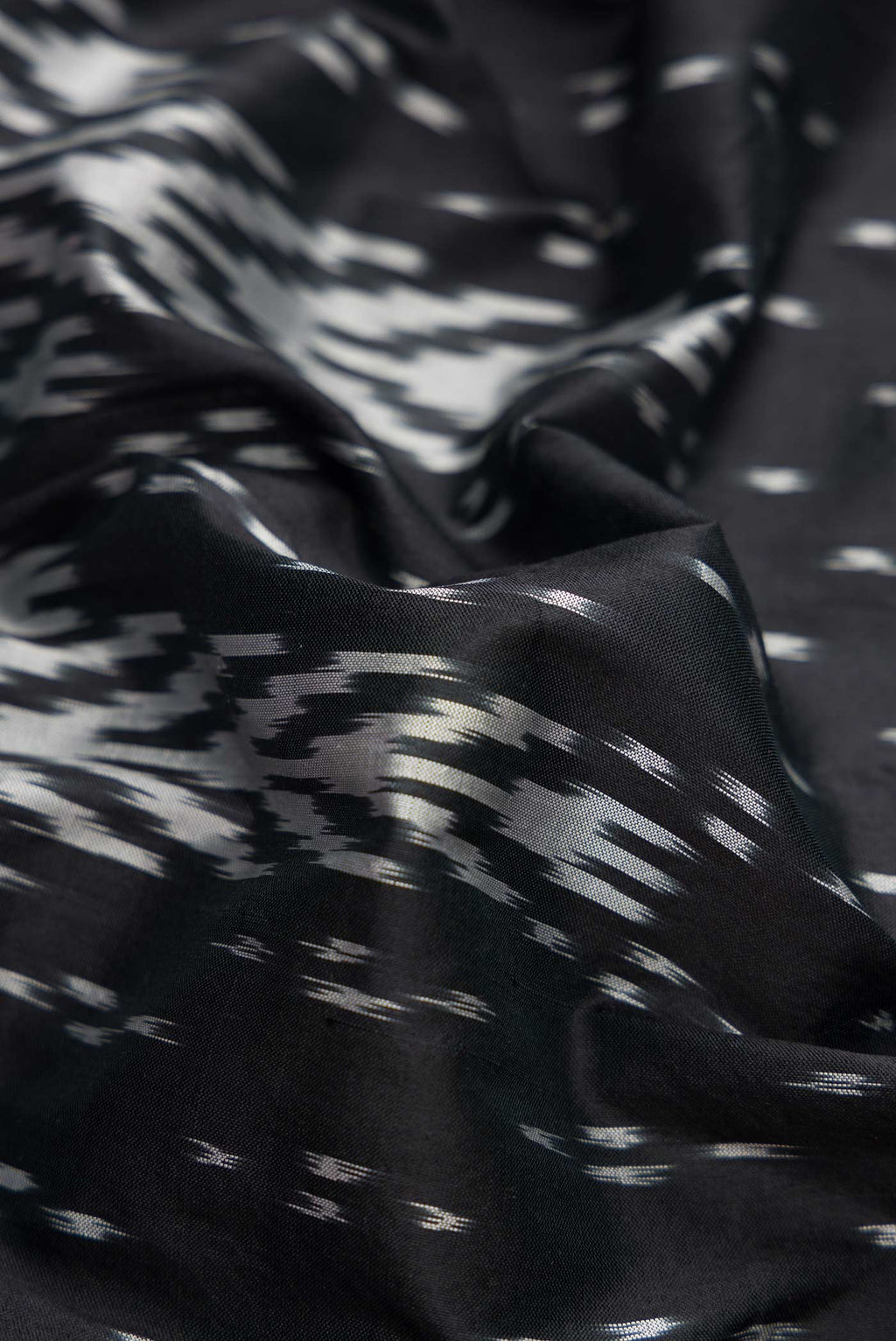 Close up of Black Dual Tone Double Ikat Saree with Ikat Print on the body and Ikat Border.  displaying folds