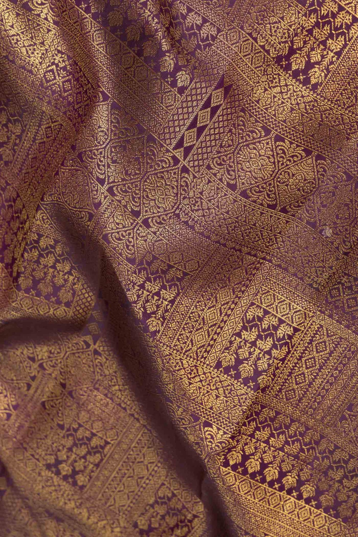 Close up of Burgundy Dual Tone Kanchipuram Saree with Zari Brocade on the body and Zari Border displaying folds