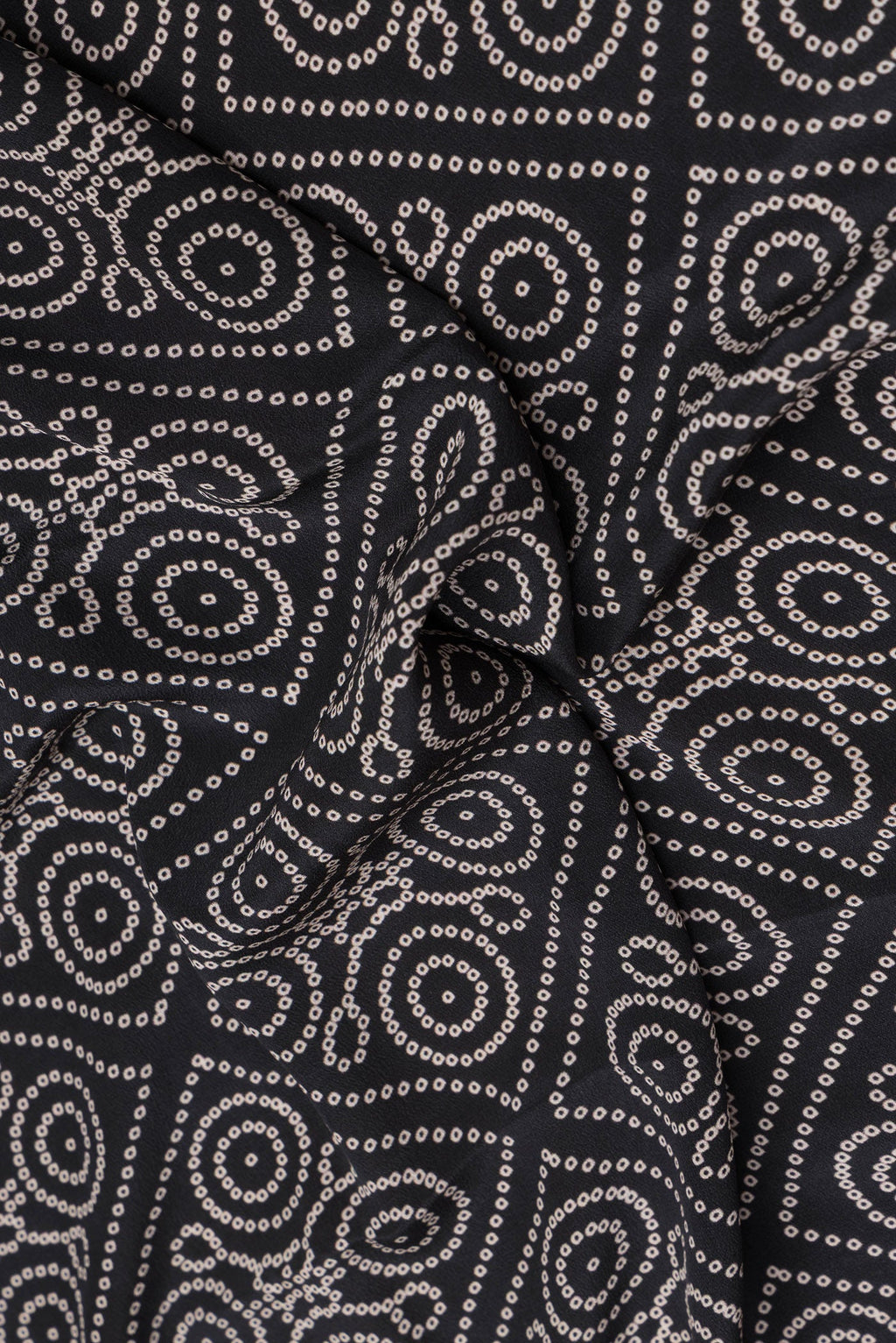 Close up of Black Crepe Saree with Bandhani Print on the body and Printed Border.  displaying folds
