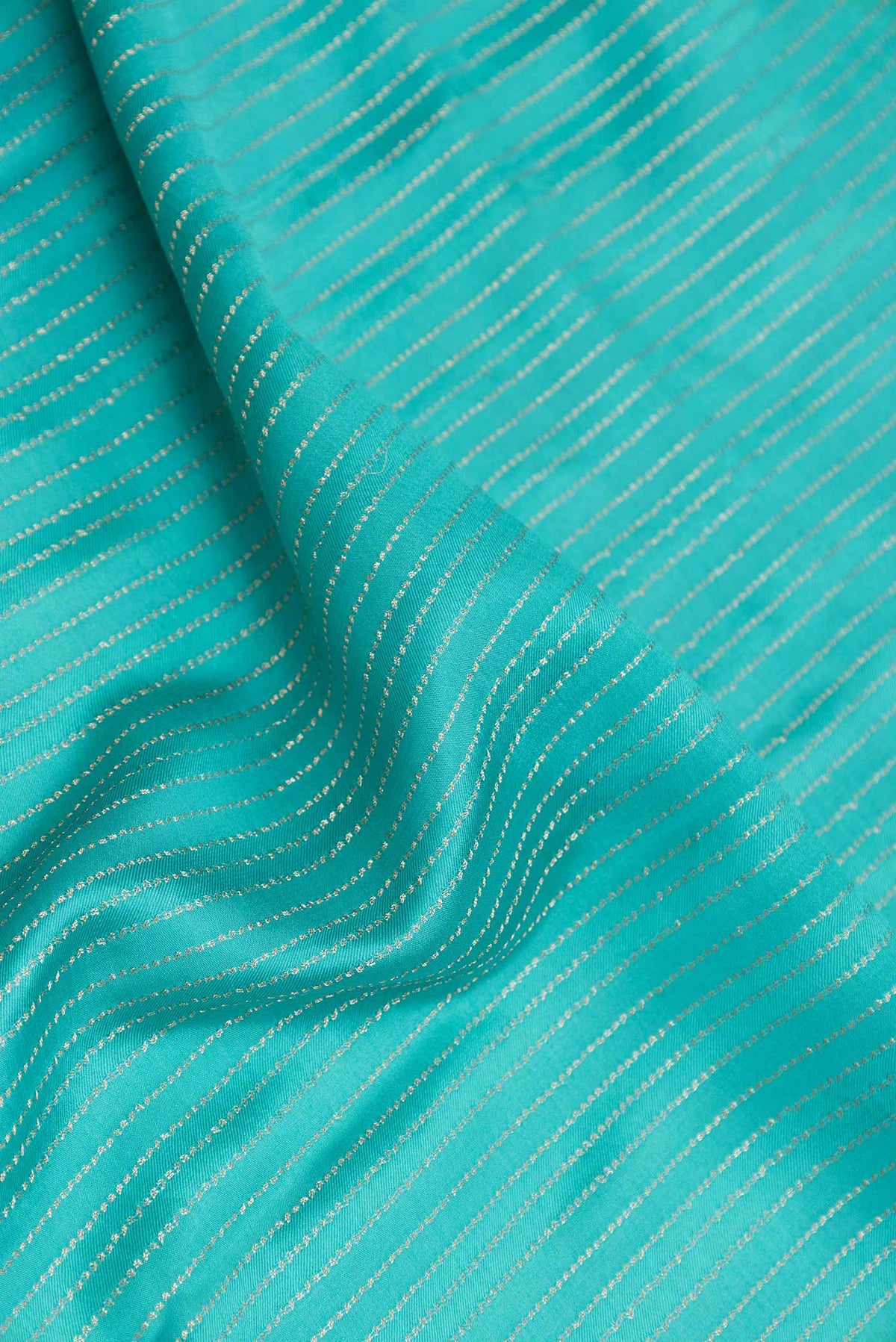 Close up of Sky Blue Mysore Crepe Saree with Stripes on the body and Zari Border displaying folds