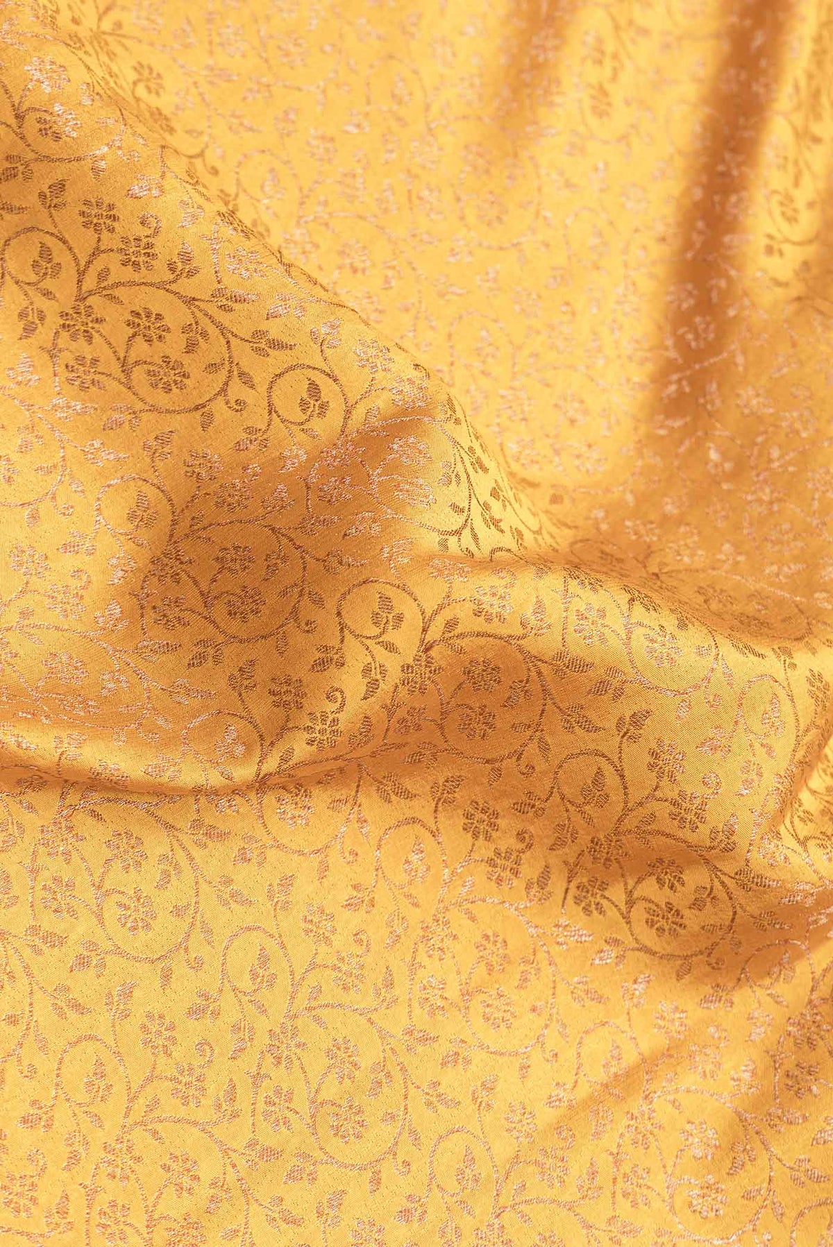Close up of Mustard Dual Tone Banarasi Silk Saree with Zari Brocade on the body and Zari Border.  displaying folds