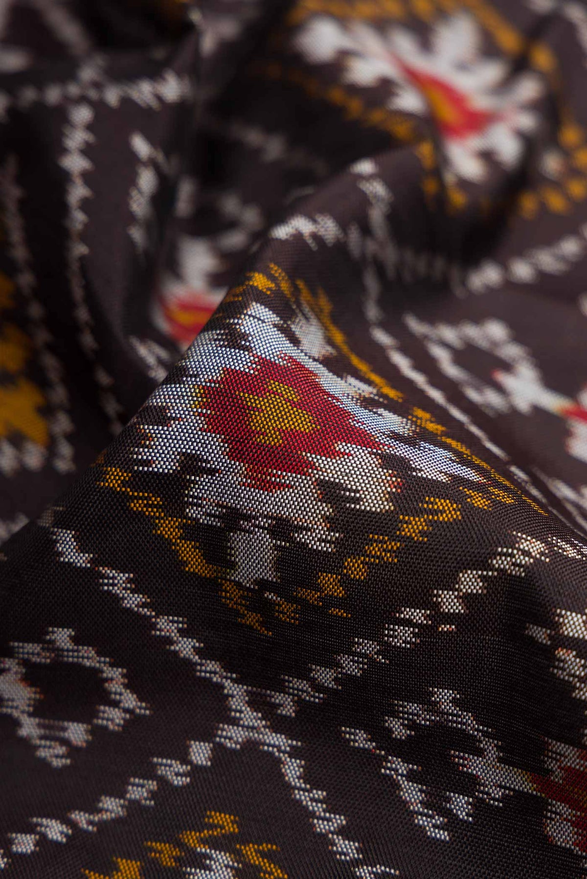 Close up of Black Pochampally Silk Saree with Pure Ikat on the body and Plain Border displaying folds