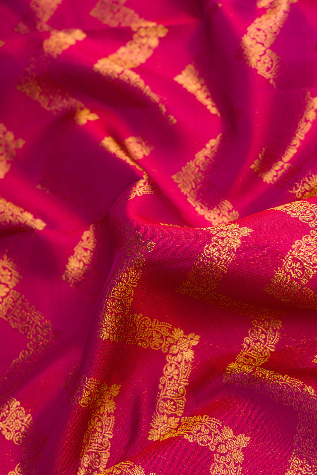 Close up of Magenta Kanchipuram Silk Saree with Zari Brocade on the body and Zari Border.  displaying folds