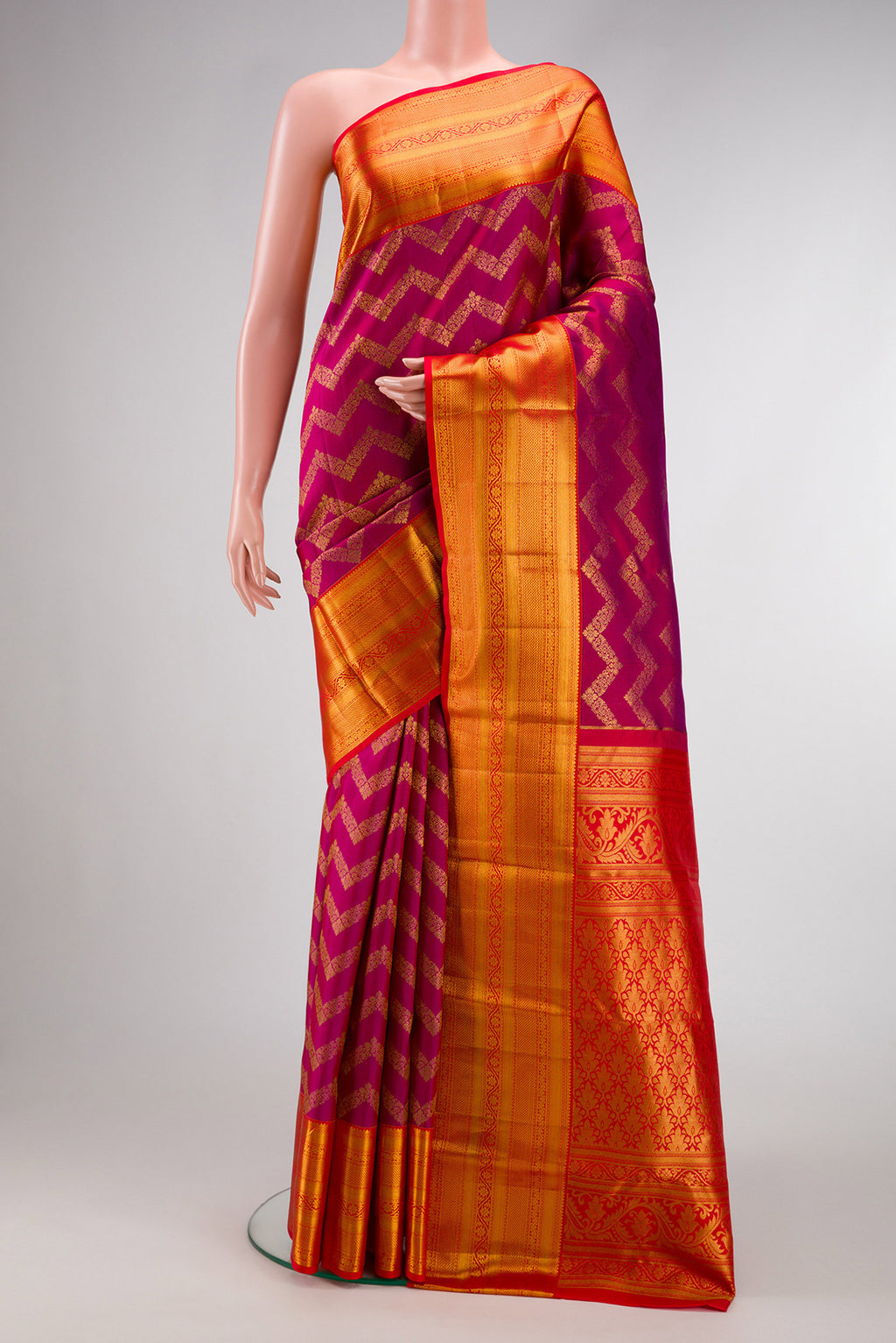 Magenta Kanchipuram Silk Saree with Zari Brocade on the body and Zari Border.  displayed on a mannequin