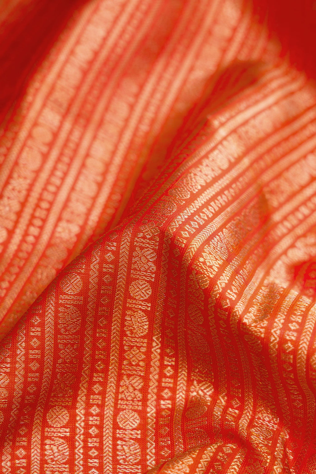 Close up of Orange Kanjivaram Silk Saree with Zari Brocade on the body and Zari Border.  displaying folds