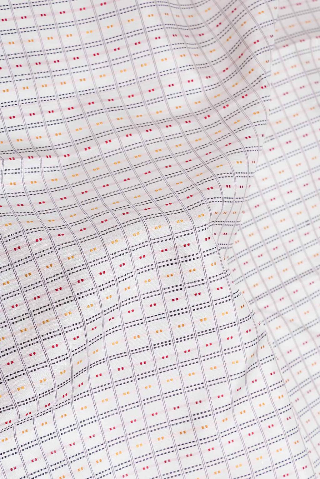 Close up of Off White Dual Tone Kanchipuram Saree with Checked design on the body and Zari Border displaying folds
