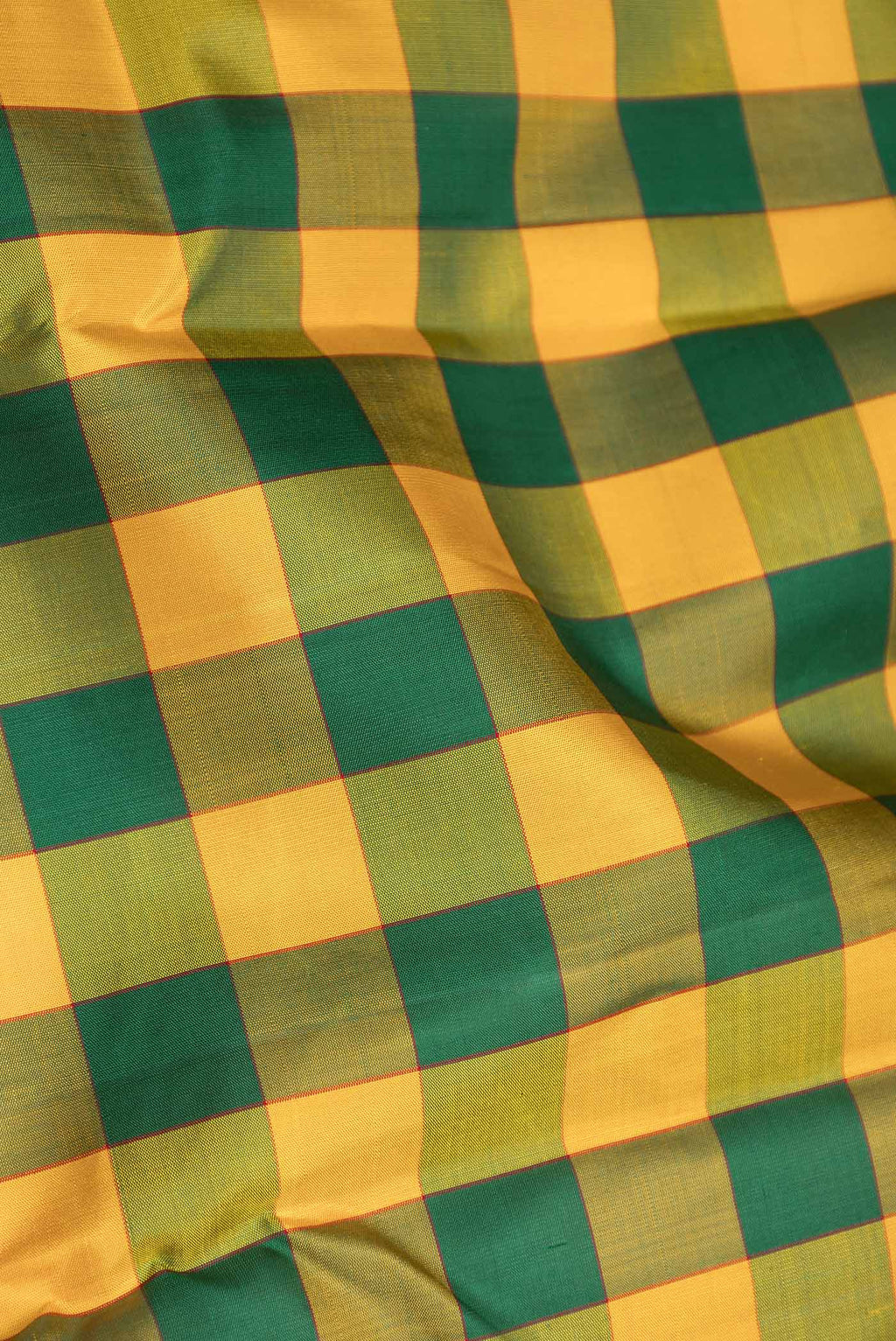 Close up of Yellow and Green Color Kanchipuram Saree with Checked design on the body and Zari Border displaying folds