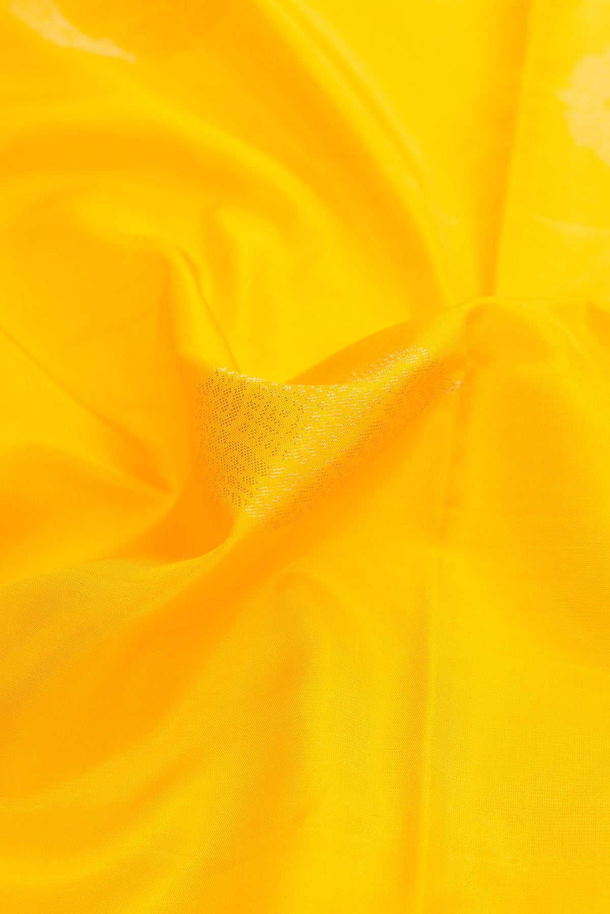 Close up of Yellow Dual Tone Soft Silk Saree with Zari Butta on the body and Zari Border.  displaying folds