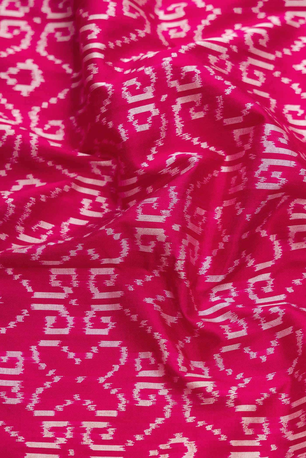 Close up of Pink Dual Tone Double Ikat Saree with Ikat Print on the body and Thread Border displaying folds
