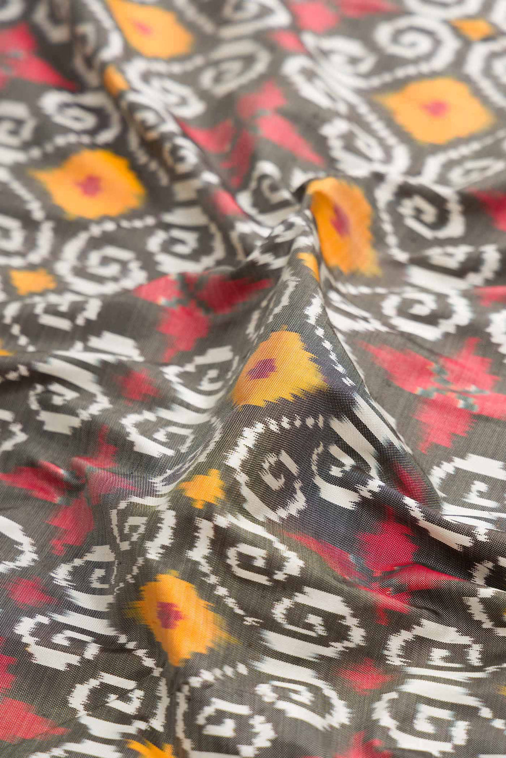 Close up of Grey Dual Tone Double Ikat Saree with Ikat Print on the body and Thread Border displaying folds