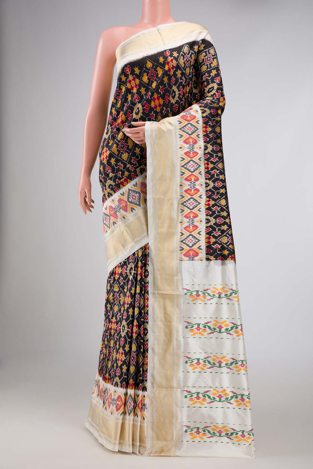 Black Dual Tone Double Ikat Saree with Ikat Print on the body and Ikat Border displayed on a mannequin