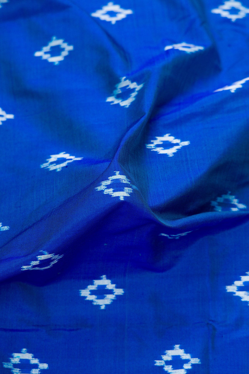 Close up of Peacock Blue Dual Tone Double Ikat Nine Yards Saree with Ikat Print on the body and Zari Border.  displaying folds