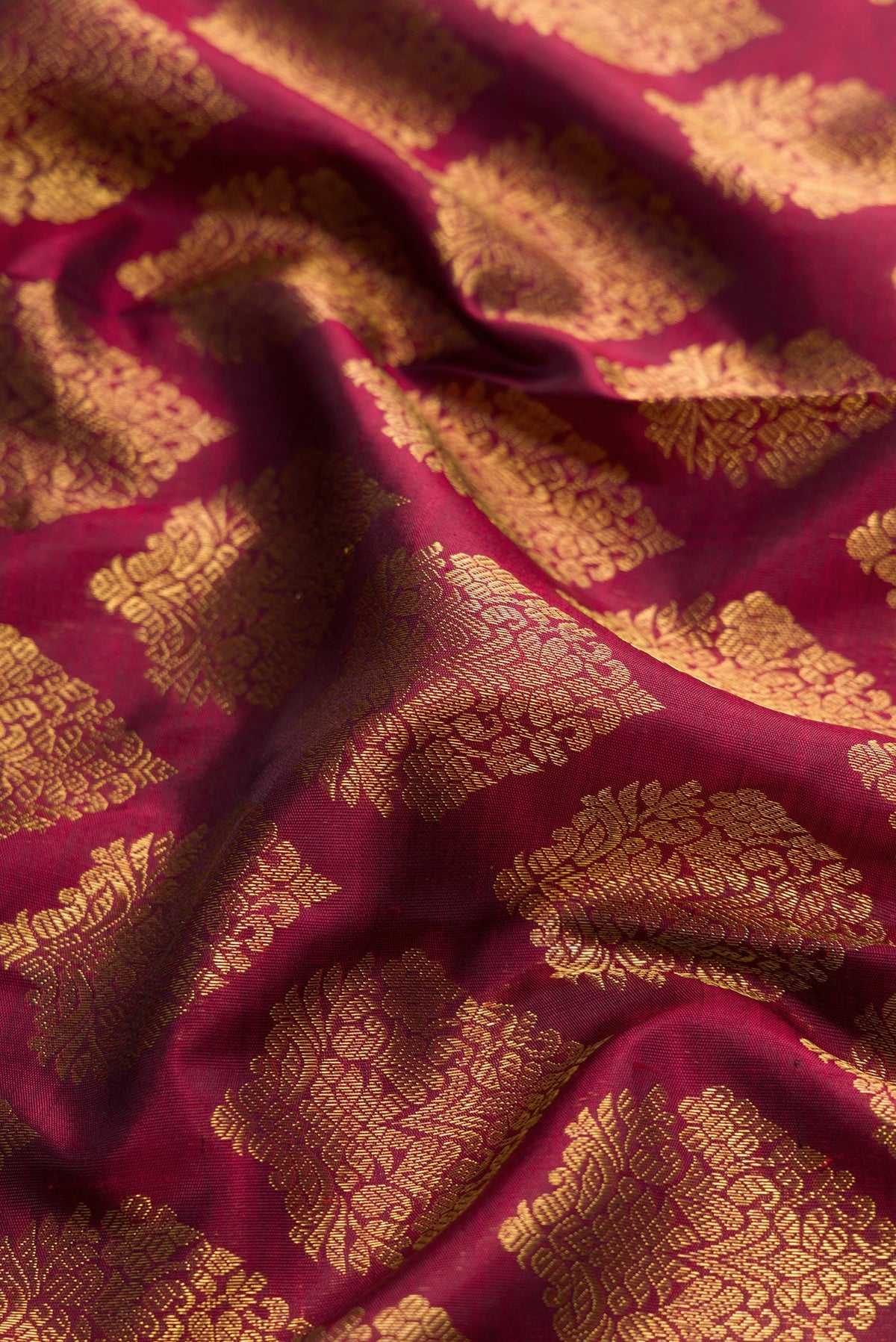 Close up of Pure Silk Pure Zari Maroon Dual Tone Kanjivaram Saree with Zari Brocade on the body and Zari Border.  displaying folds