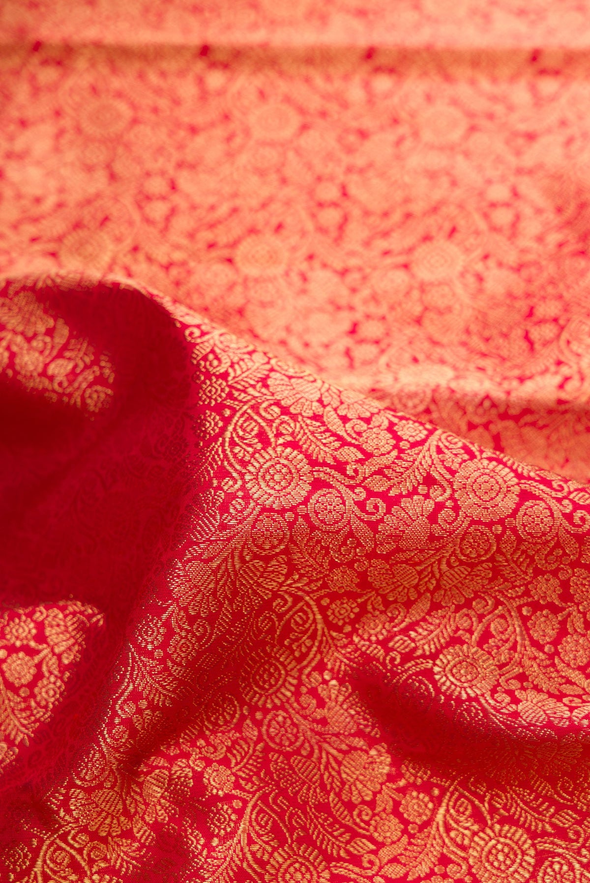 Close up of Pure Silk Pure Zari Red Dual Tone Kanjivaram Saree with Zari Brocade on the body and Zari Border.  displaying folds
