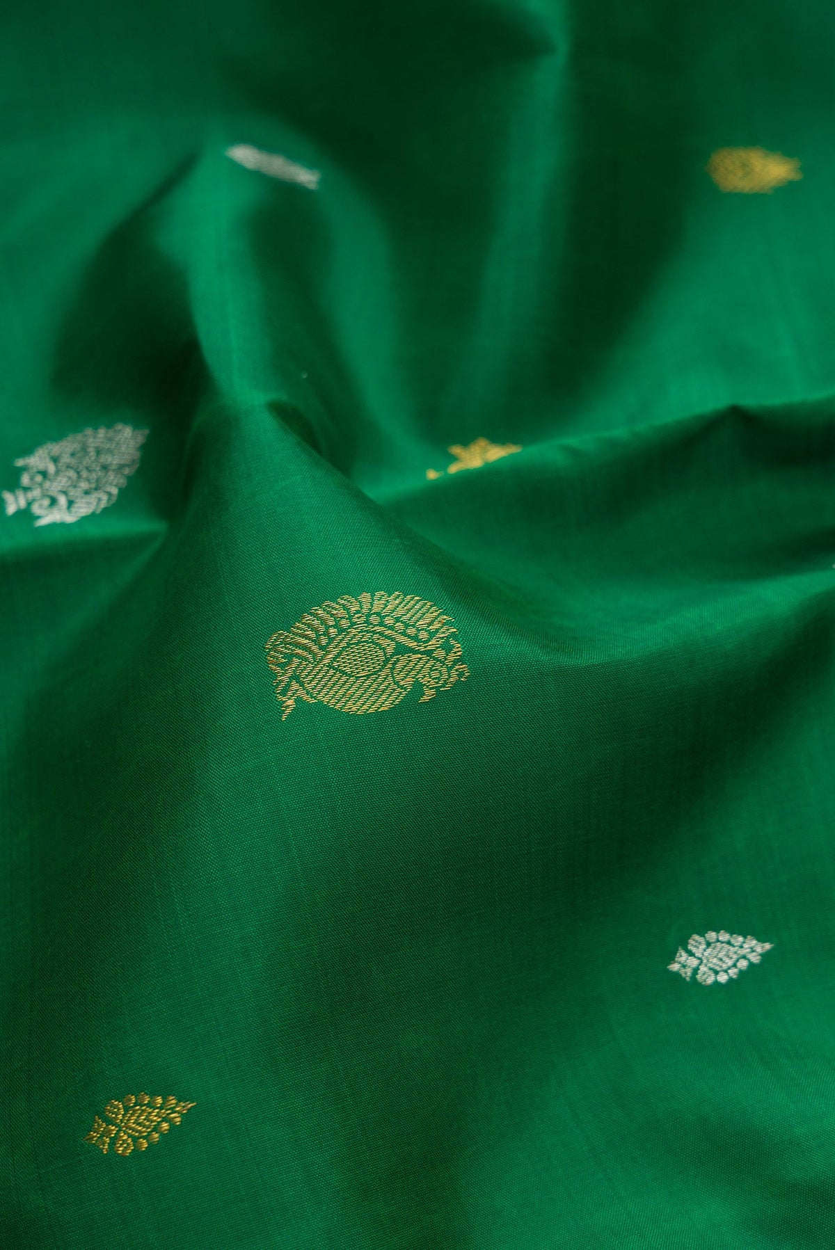 Close up of Pure Silk Pure Zari Green Dual Tone Kanchipuram Saree with Zari Butta on the body and Zari Border.  displaying folds