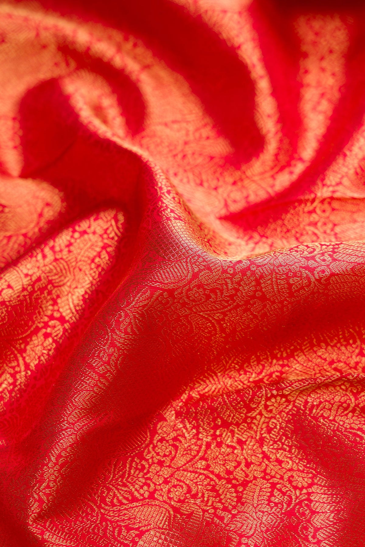Close up of Pure Silk Pure Zari Red Dual Tone Kanjivaram Saree with Zari Brocade on the body and Zari Border.  displaying folds