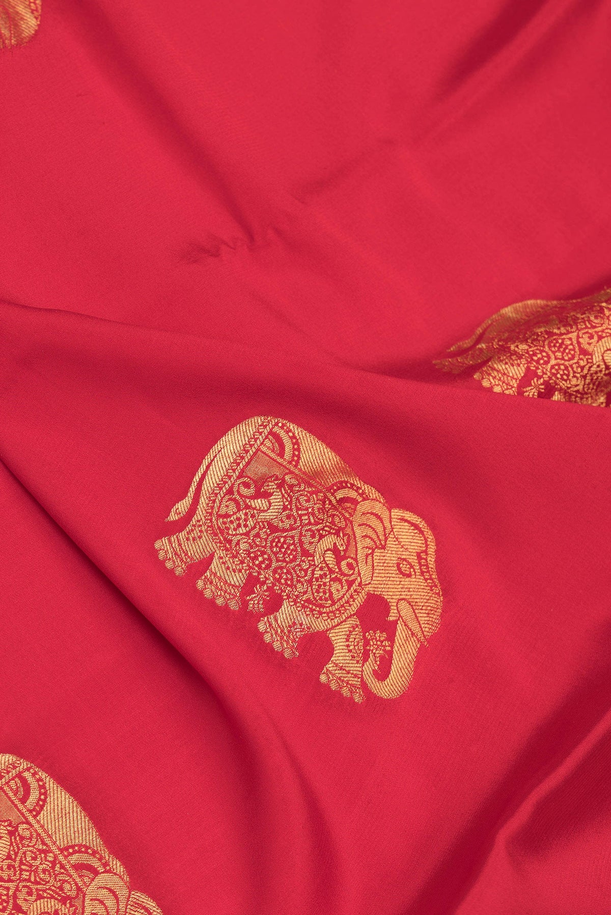 Close up of Red Dual Tone Mysore Silk Saree with Zari Butta on the body and Zari Border.  displaying folds