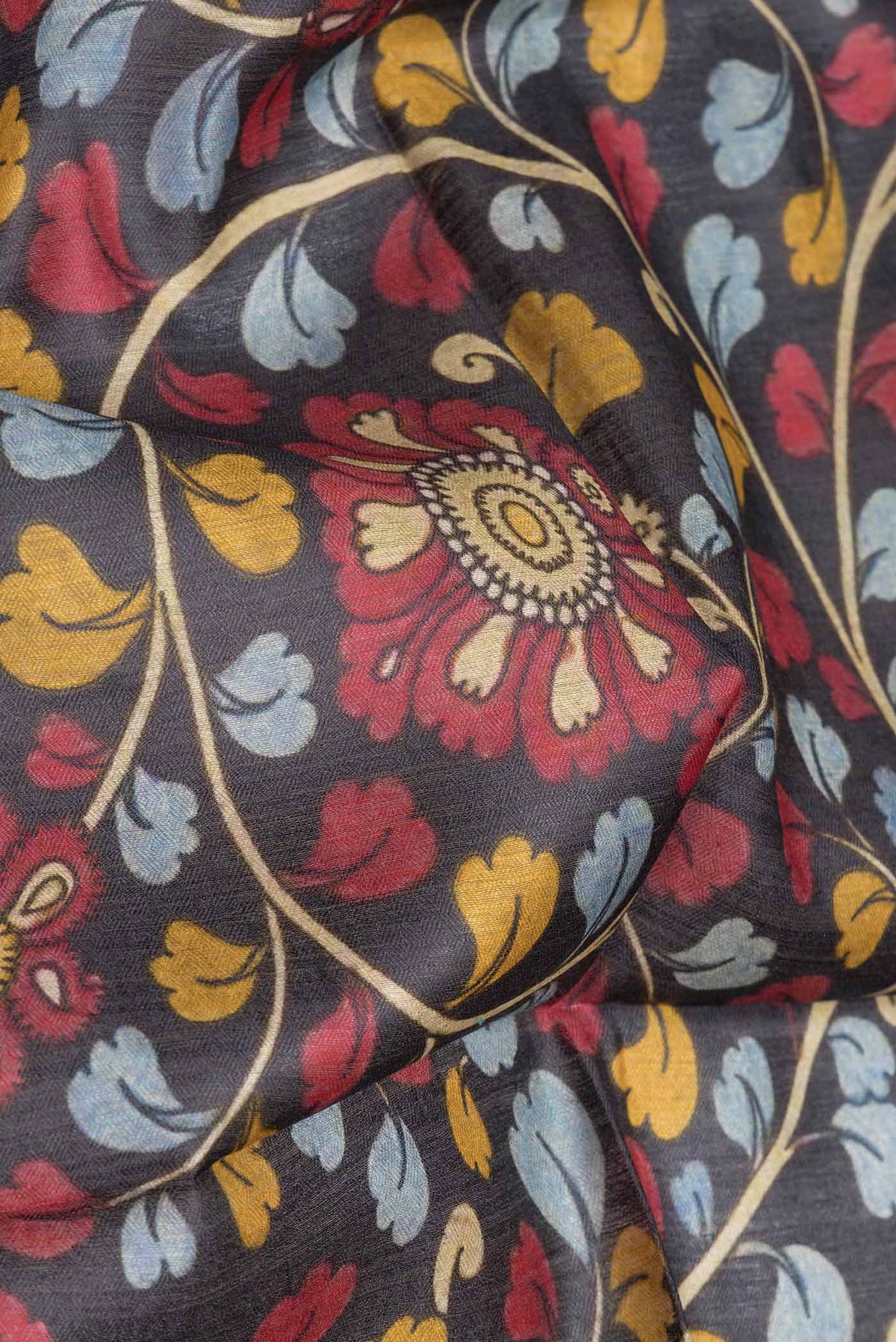 Close up of Black Dual Tone Tussar Saree with kalamkari Print on the body and Zari Border.  displaying folds