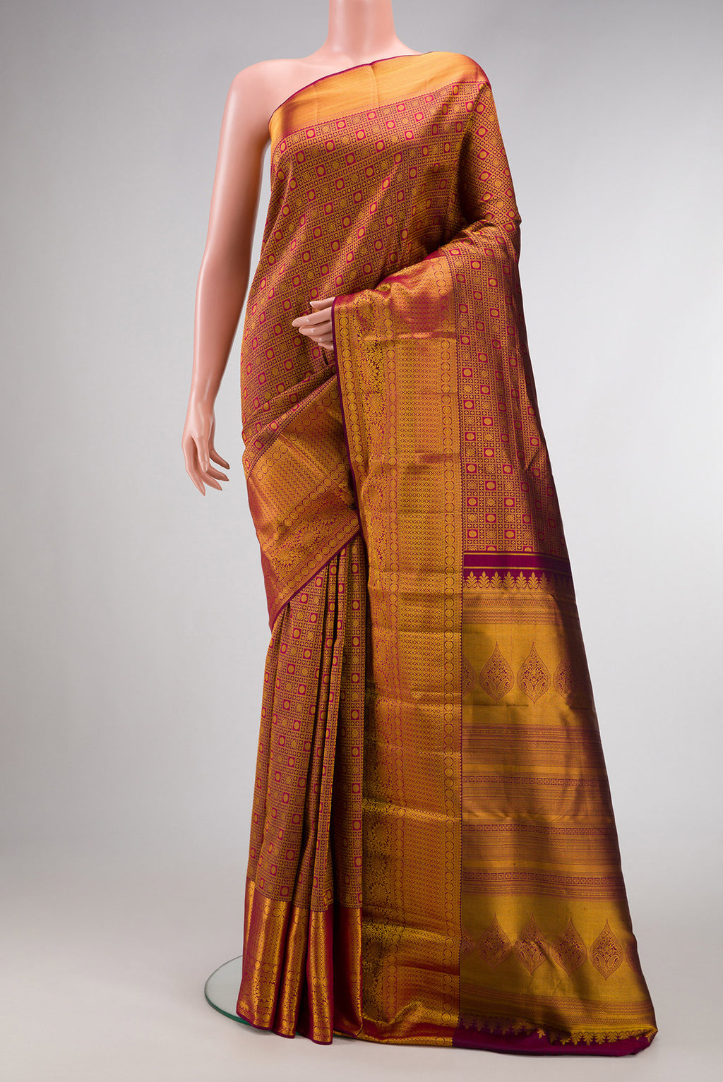Magenta Kanjivaram Silk Saree with Zari Brocade on the body and Fancy Border.  displayed on a mannequin