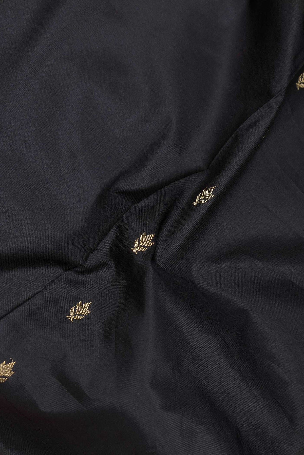 Close up of Black Bangalore Silk Saree with Zari Butta on the body and Zari Border displaying folds
