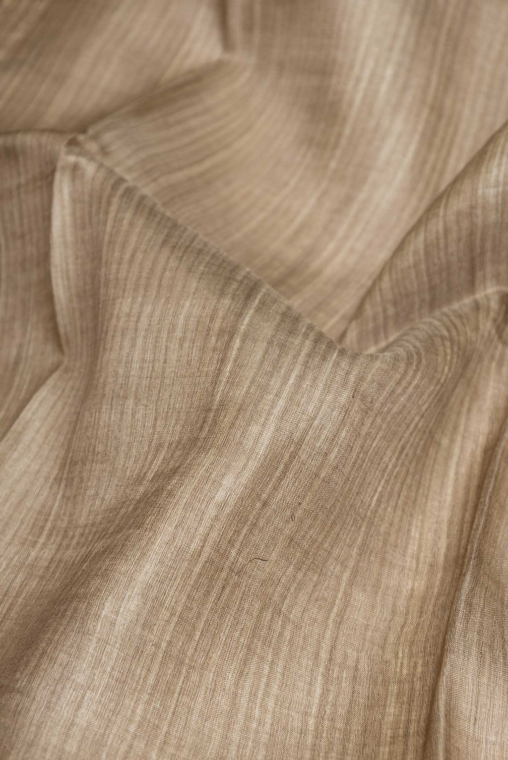 Close up of Beige Dual Tone Tussar Saree with Stripes on the body and Fancy Border displaying folds